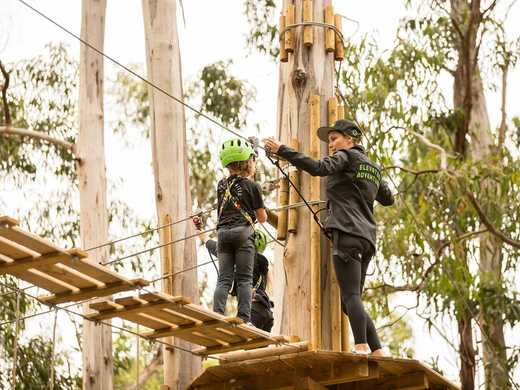 Child on a treetop adventure trail with an instructor