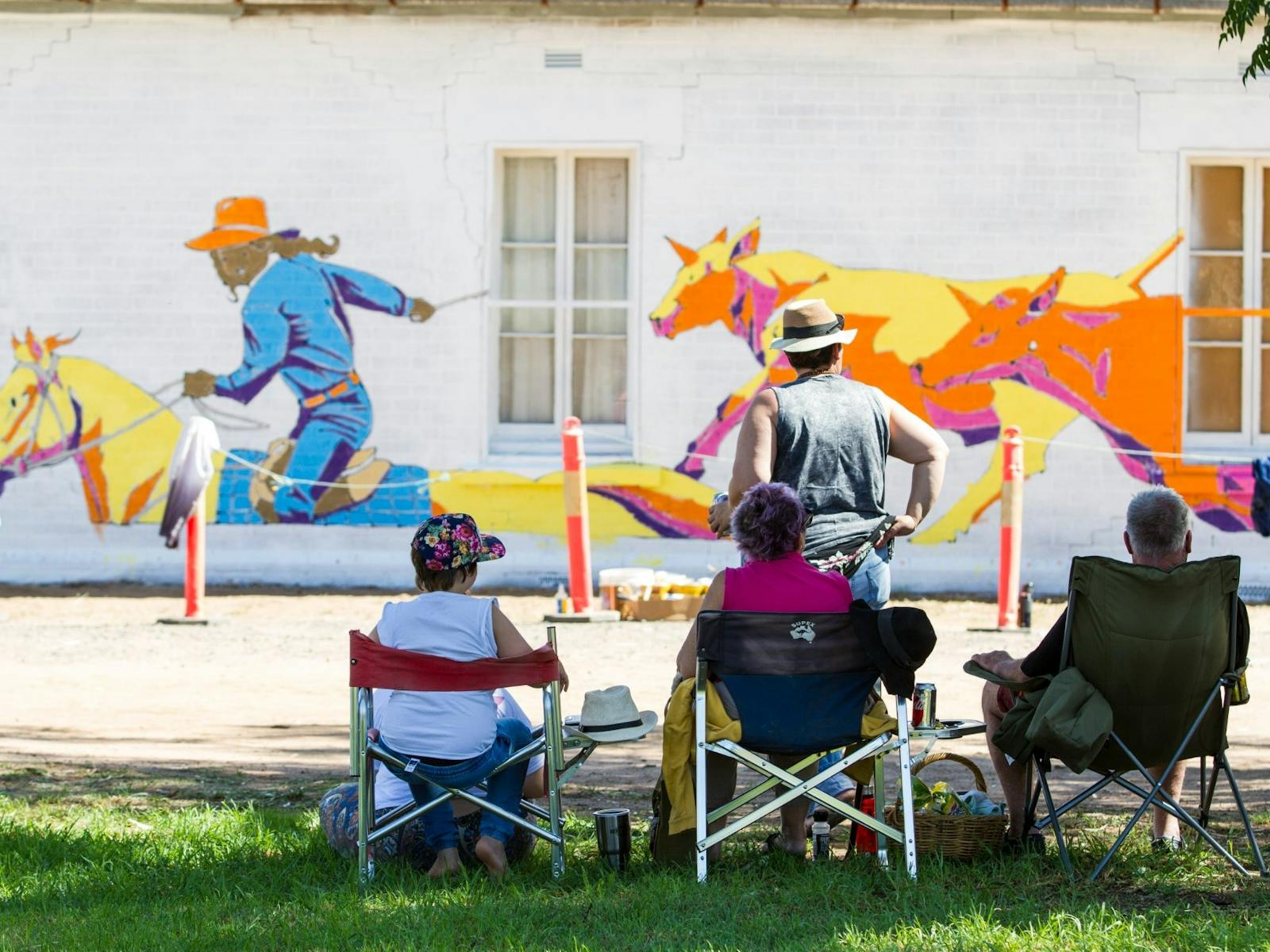 Colourful mustering scene being admired by locals after a collaborative mural effort at 2018 festiva