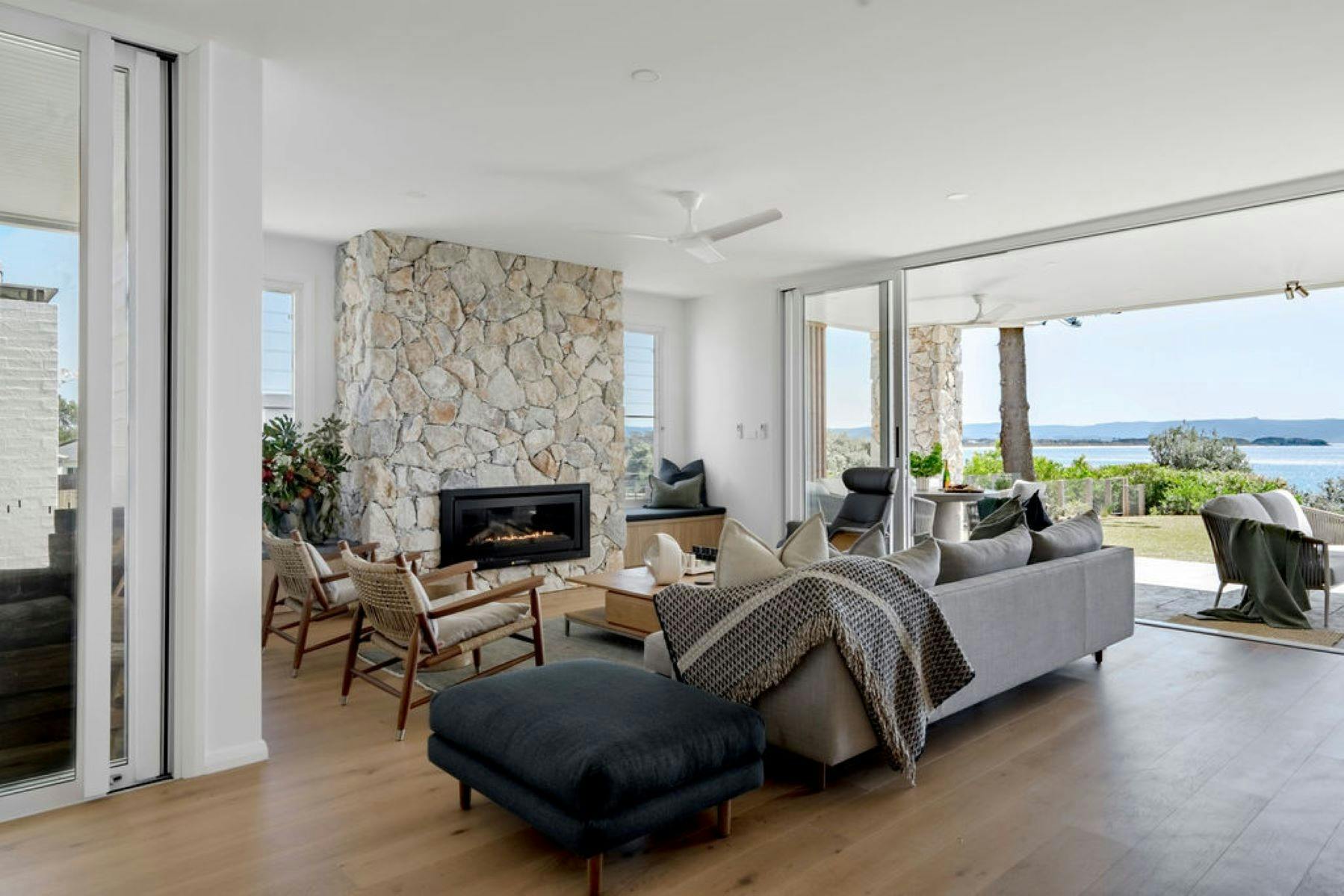 Image of the interior fireplace made of stone. Surrounded by comfortable designer furniture