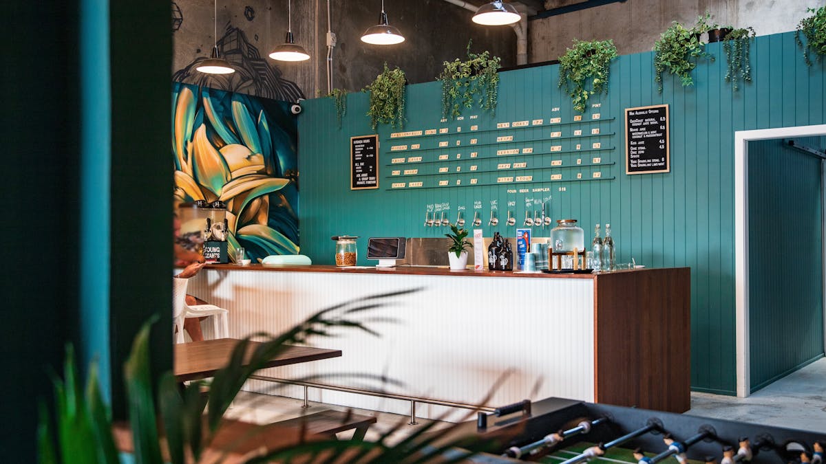 Young Giants bar glows in the afternoon light with bold mural art and coastal craft brews on tap. Young Giants bar glows in the afternoon light with bold mural art and coastal craft brews on tap.