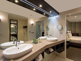 Two sinks, bathtub and shower in King One Bedroom Suite bathroom
