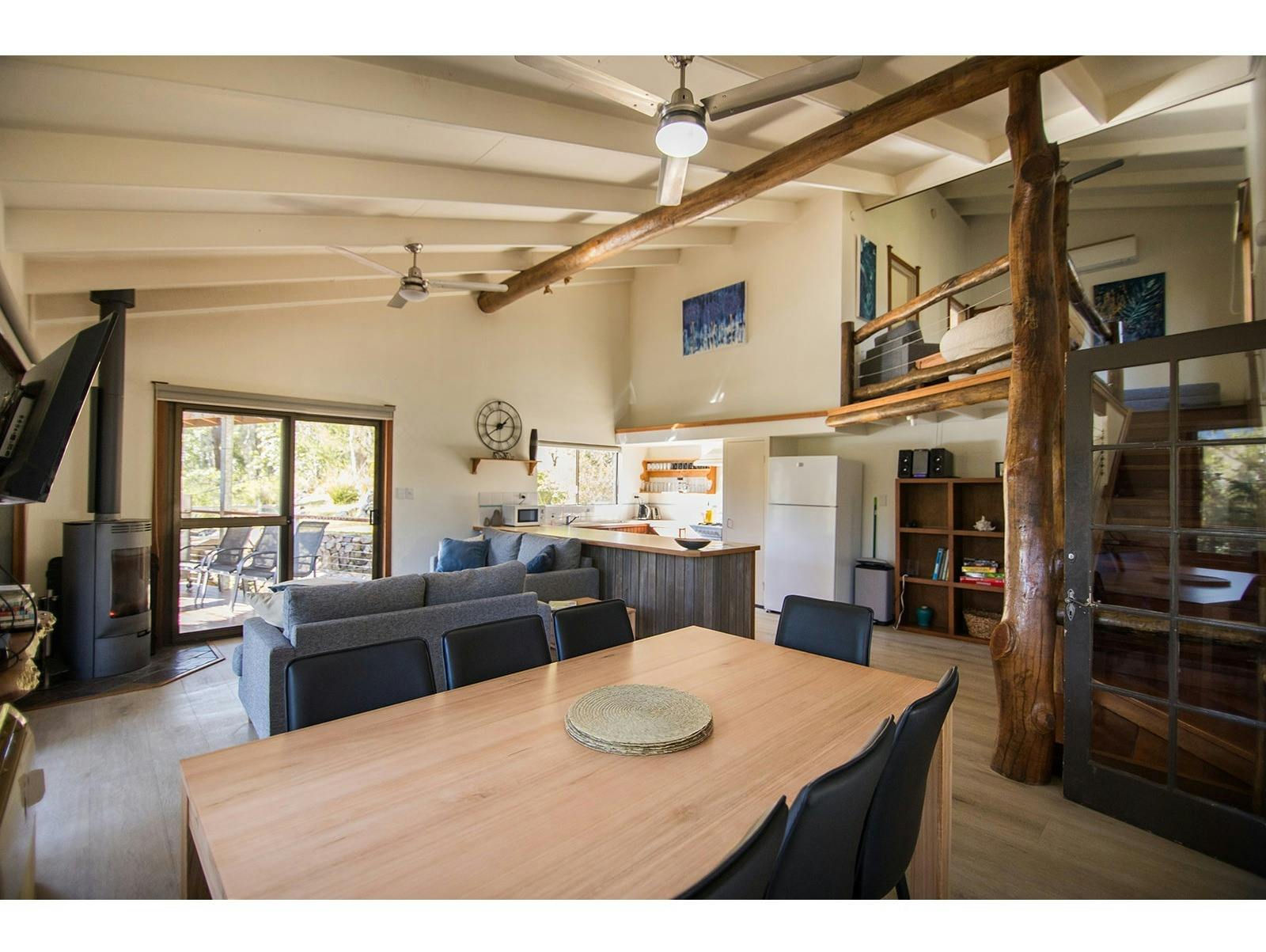 餐厅配有餐桌和可容纳 8 人的椅子，背景中有壁炉和休息区。