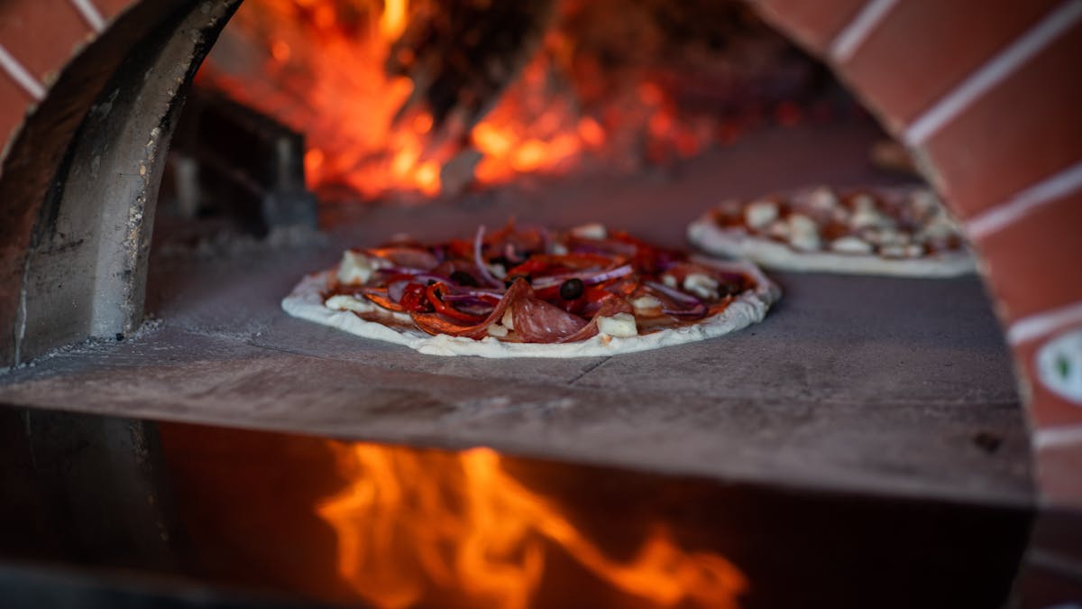 wood fired pizza cooking in a pizza oven