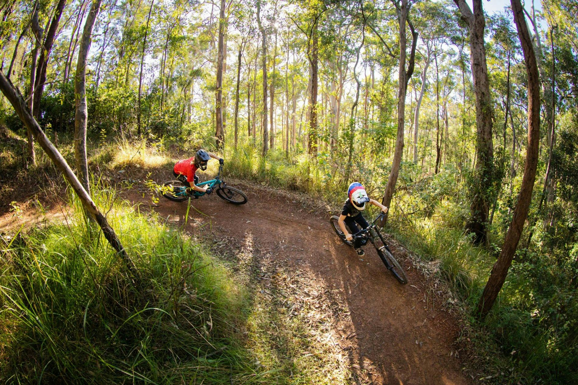 riders on berm on mountain bike