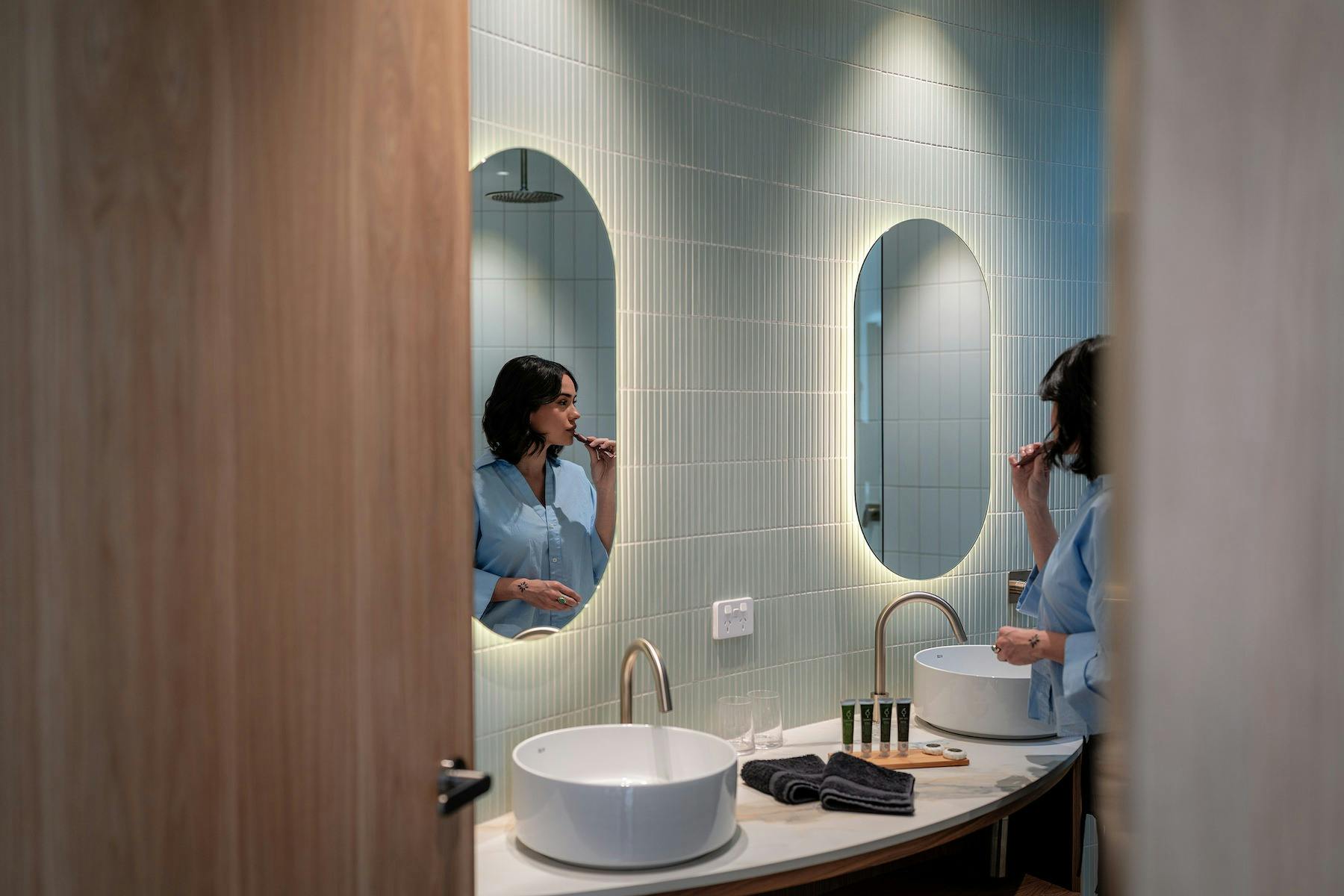 Woman brushing teeth in the bathroom at Retreat Studio at Chrismont
