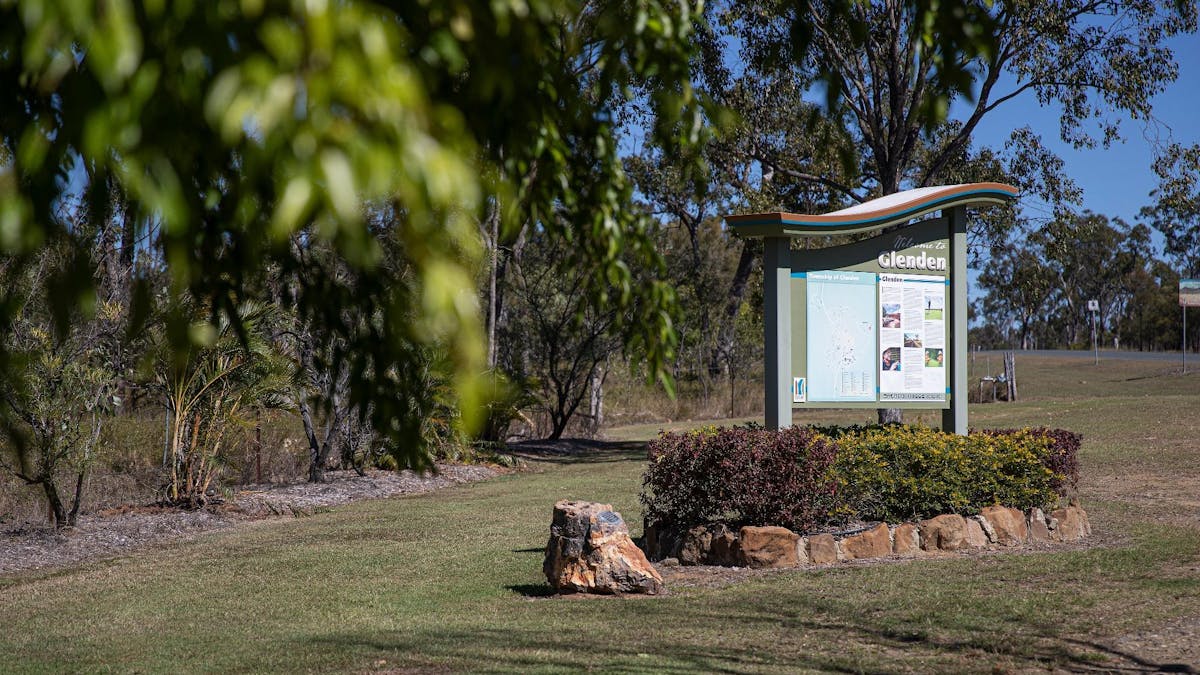 Welcome sign in a garden bed surrounded by rocks and shrubs
