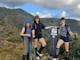 Clients at the West Ridge sign with summit of Mt Buller in the background