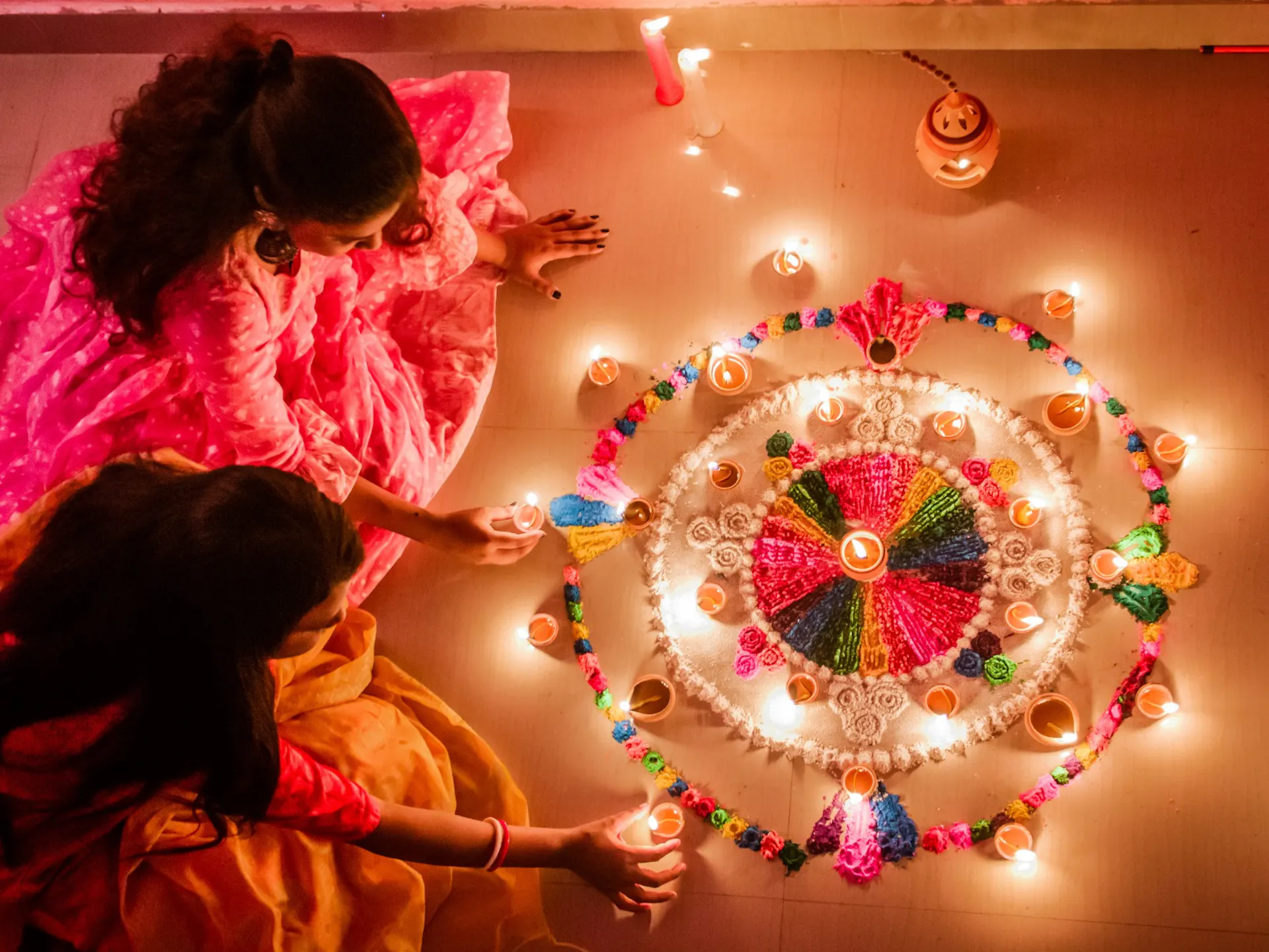 Two people sitting on the ground with a small setup of tea light candles