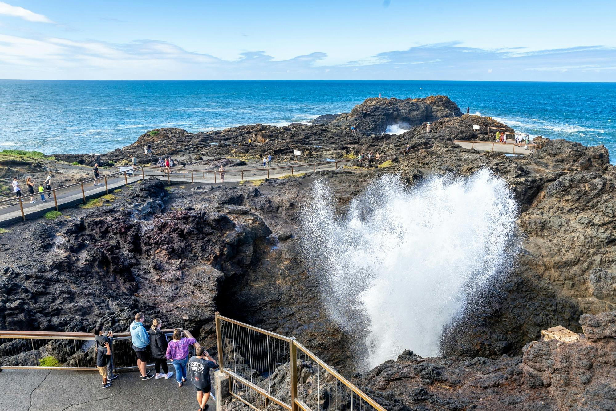 Water spurts high from Kiama Blowhole as people watch