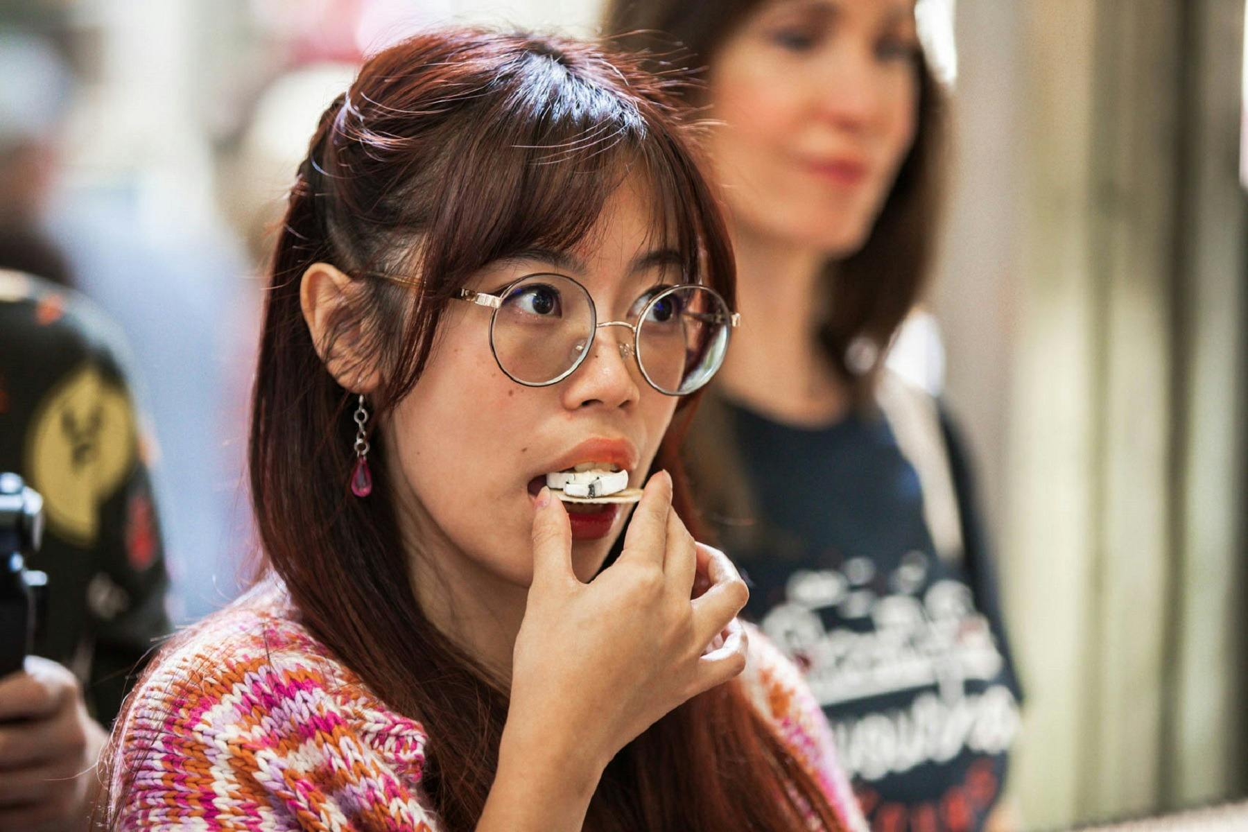 A food tour guest sampling food