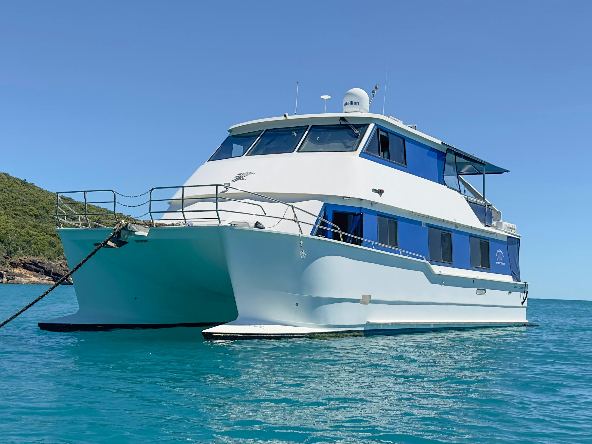 Image of large catamaran boat anchored in blue water Image of large catamaran boat anchored in blue water