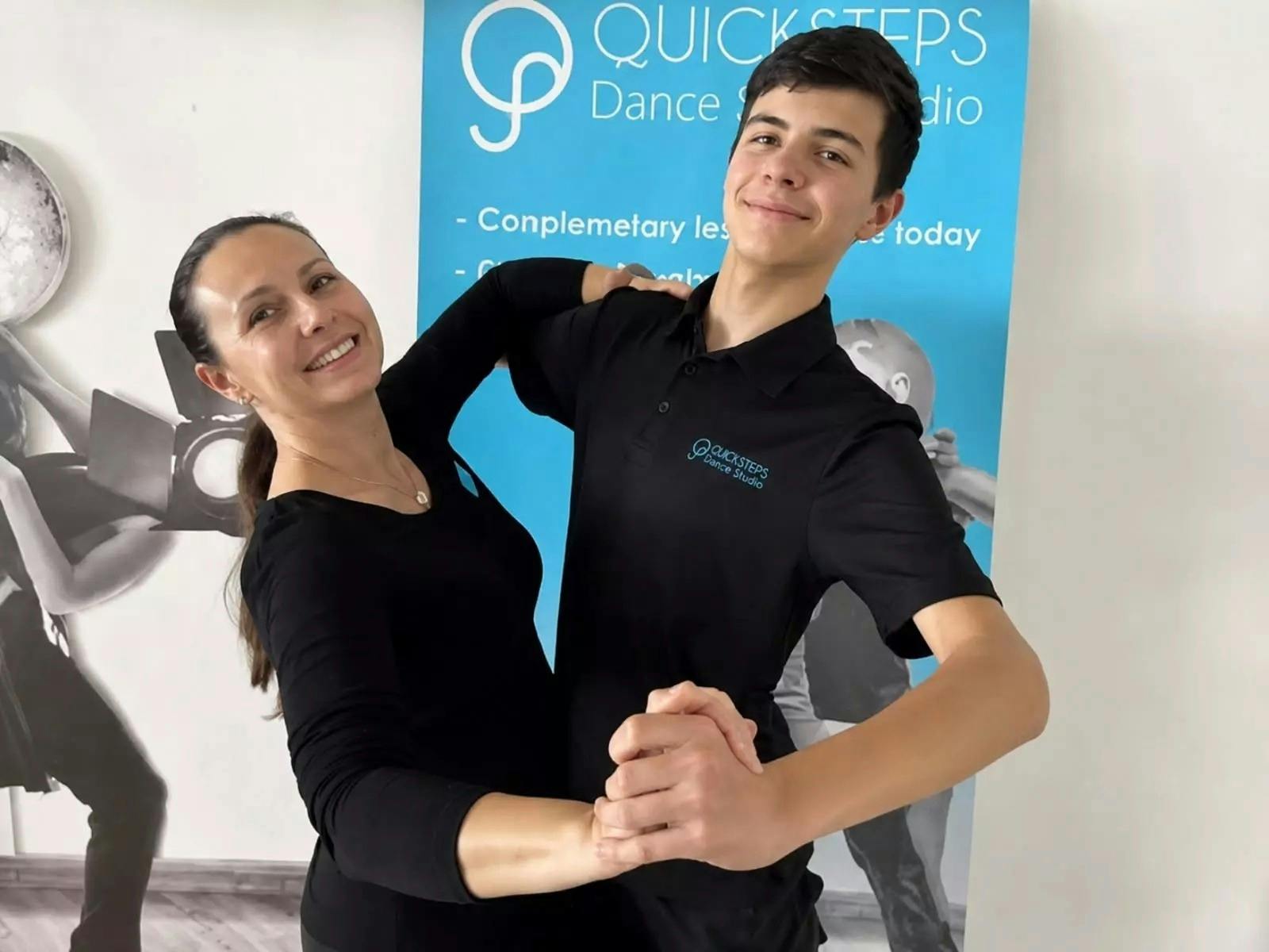 QuickSteps Dance Studio instructors smiling while practising a ballroom dance hold.