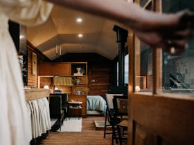 Woman opening the door to the carriage to reveal the quirky interior