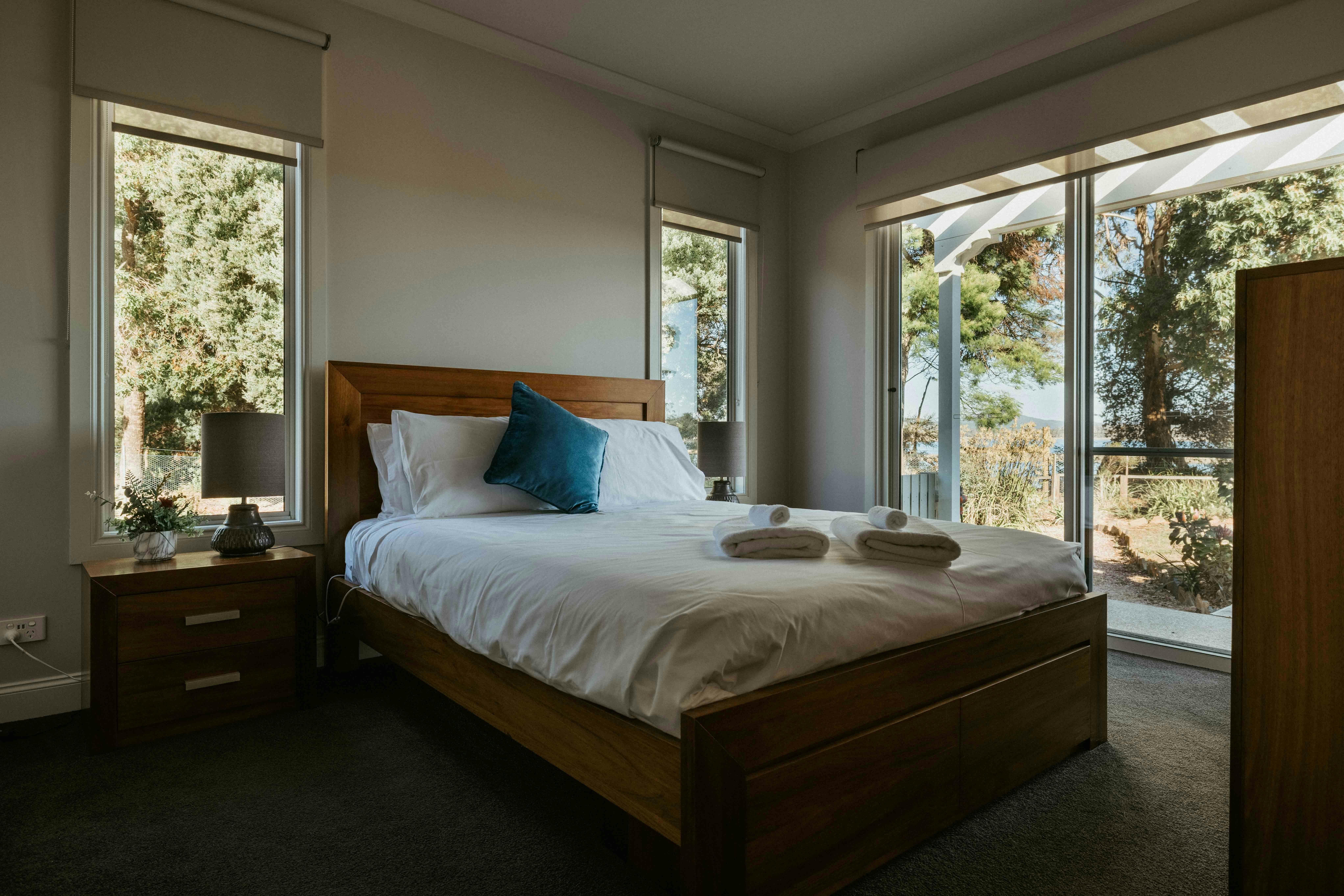 The spacious second bedroom features a queen bed with views of the Rubicon Estuary