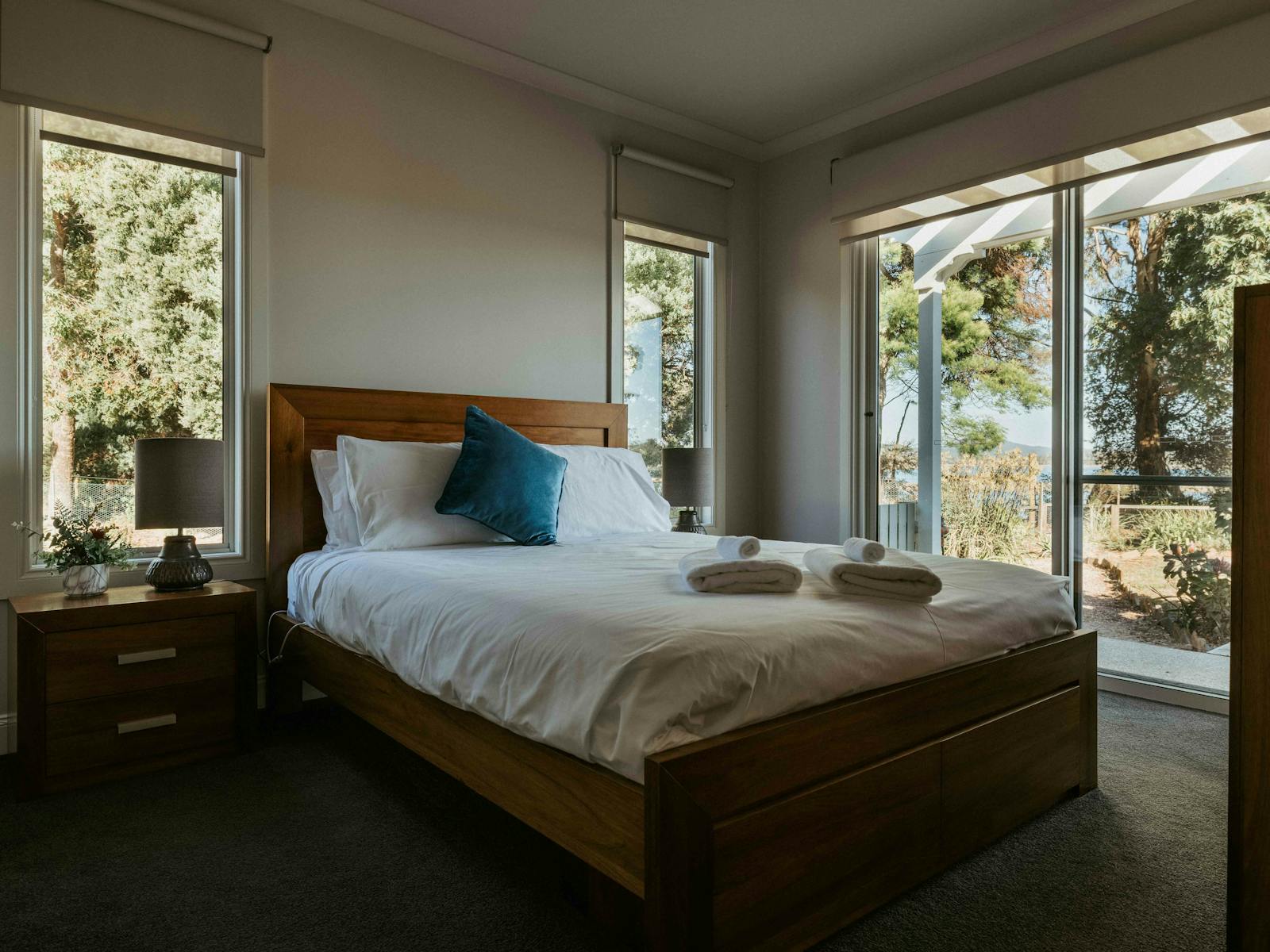 The spacious second bedroom features a queen bed with views of the Rubicon Estuary