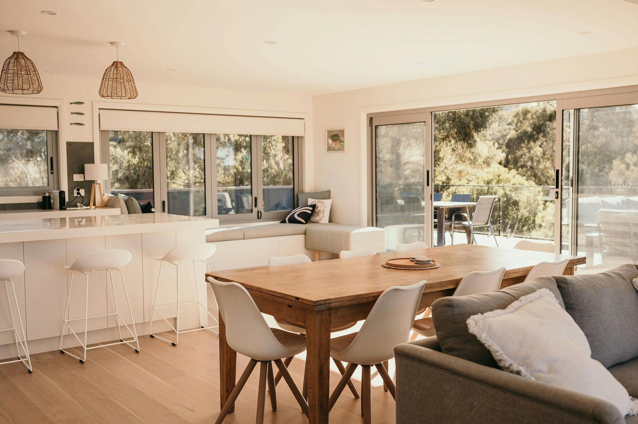 Living and dining area which flows onto an expansive deck and natural environment backdrop.