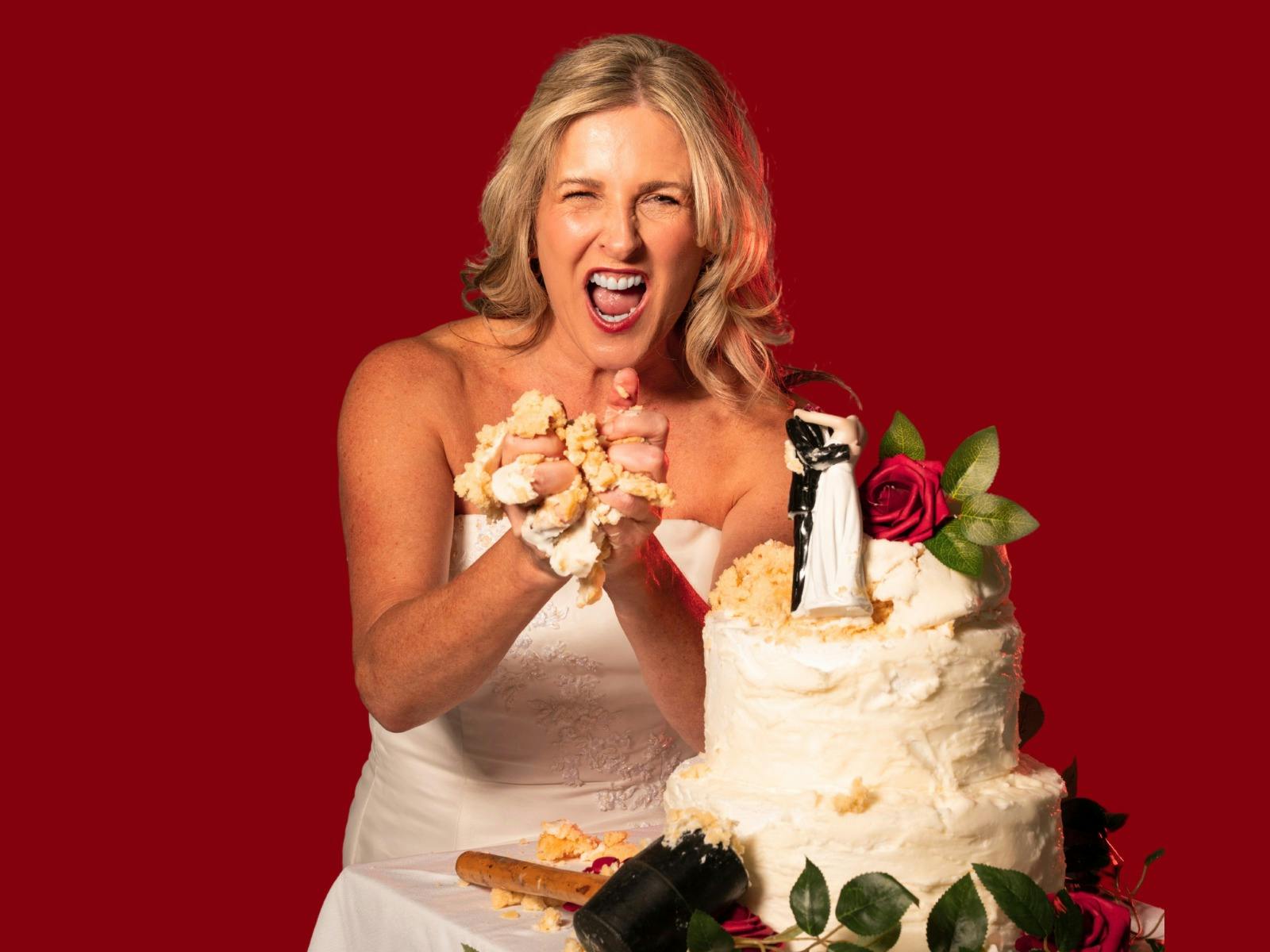 Angry blonde woman in a wedding dress destroying a wedding cake with her hands