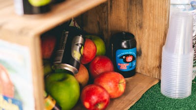 Apples and cider on display in a wooden box.