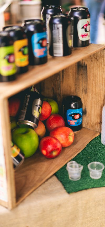 Apples and cider on display in a wooden box.