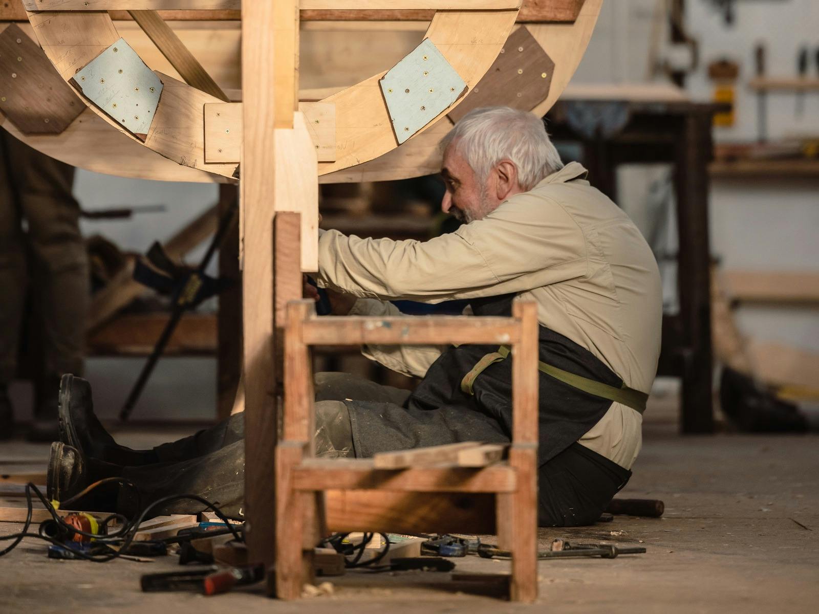 person working on a wooden boat construction