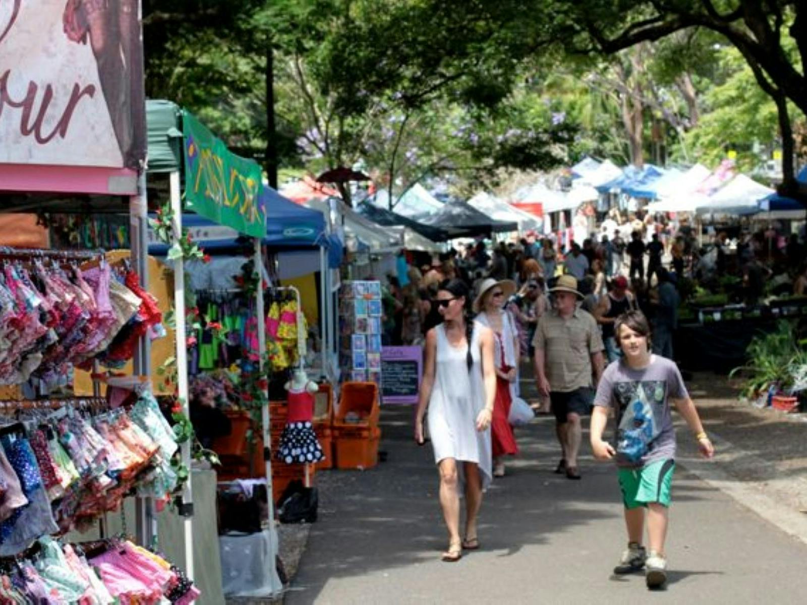 People looking at stalls under trees