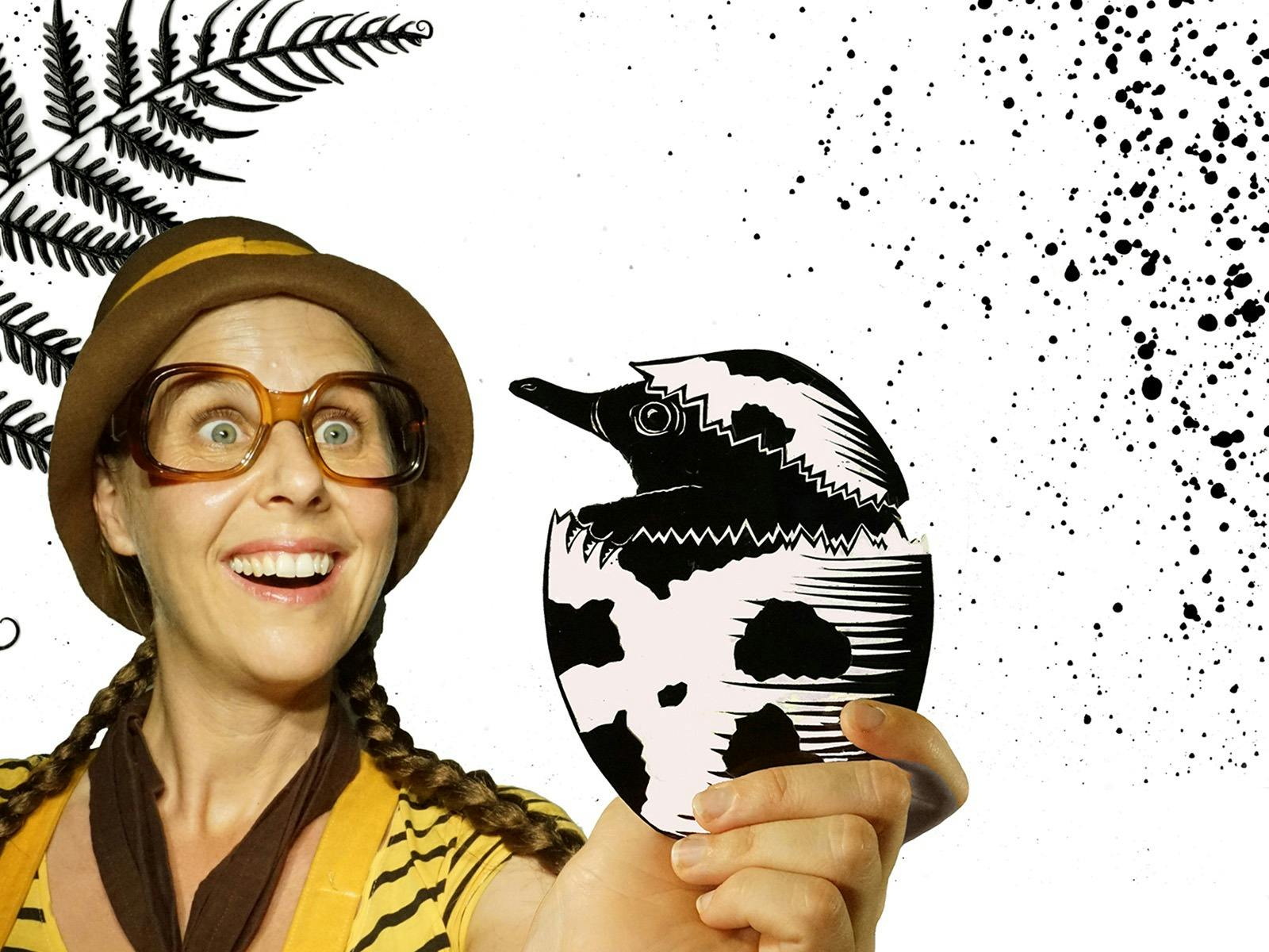 Girl with glasses holding a shadow puppet echidna hatching out of an egg