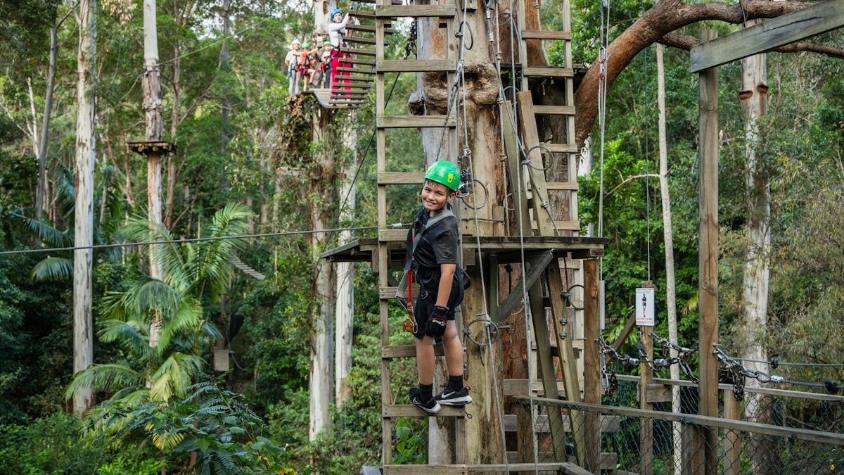 Kids 8 and older can climb on the course. Kid climbing down a ladder