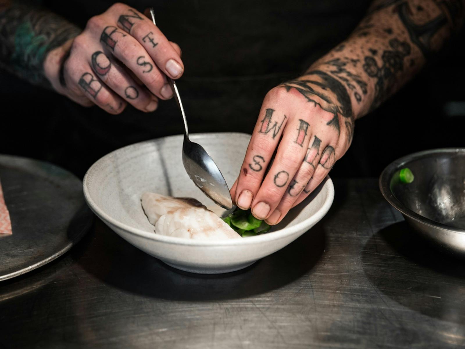 Head Chef Malcolm Hanslow plating a dish of steamed fish and greens.