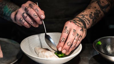 Head Chef Malcolm Hanslow plating a dish of steamed fish and greens.