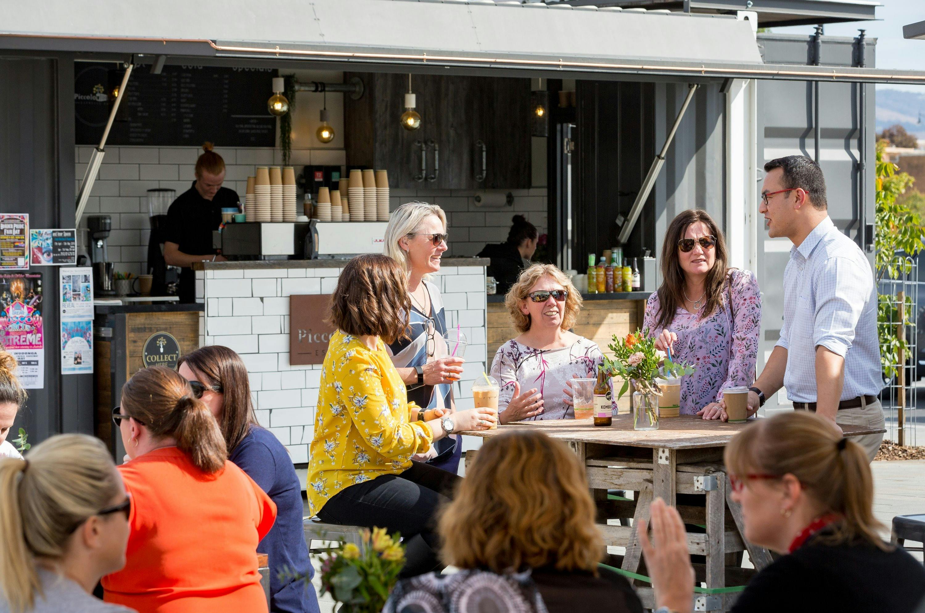 ジャンクションプレイスのピッコロポッドでドリンクを楽しむ人々