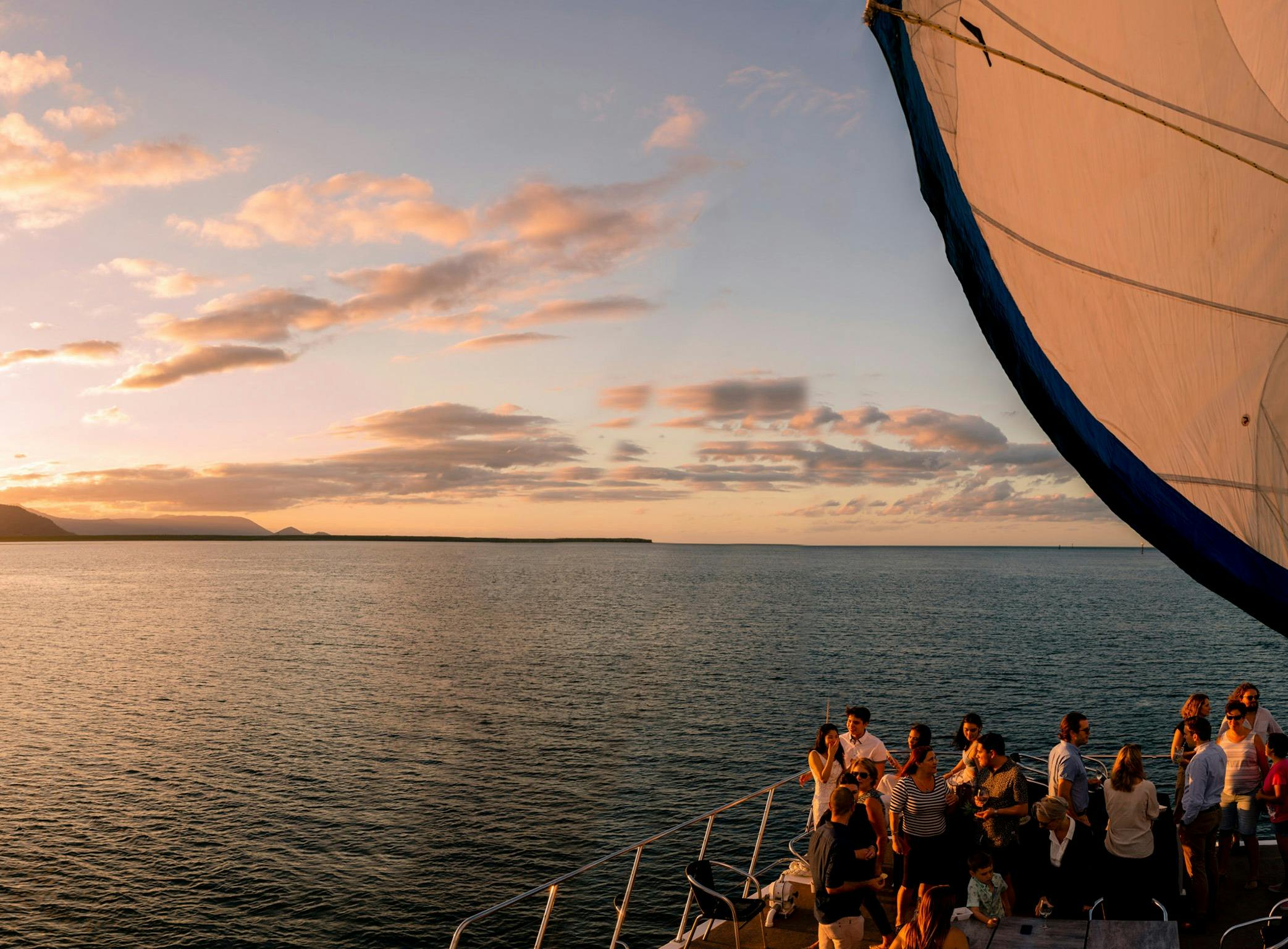Panoramic views over sea, sunset and mountains from bow of catamaran