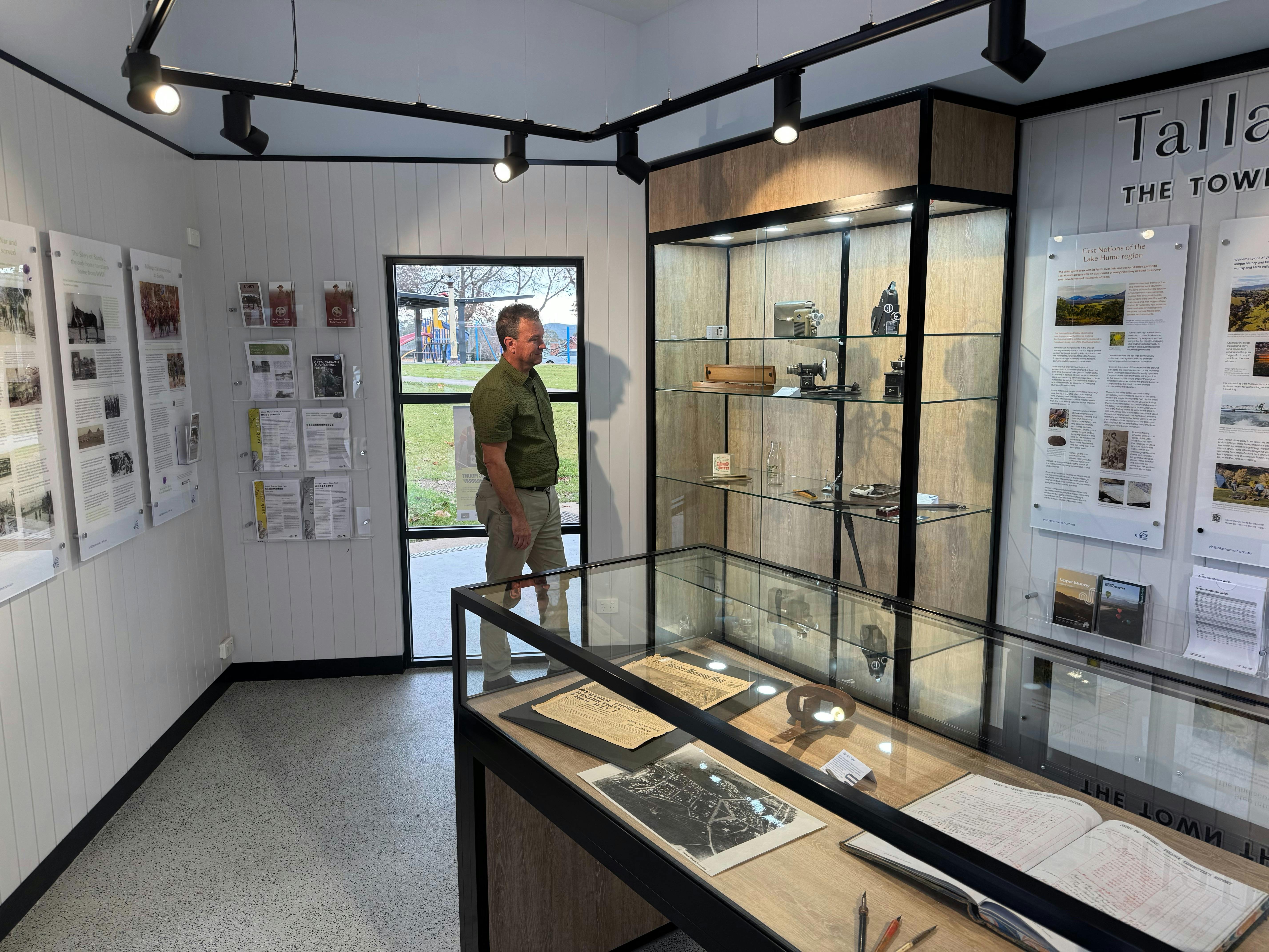 a person looking at cabinets of artifacts at the Tallangatta Visitor Information Centre