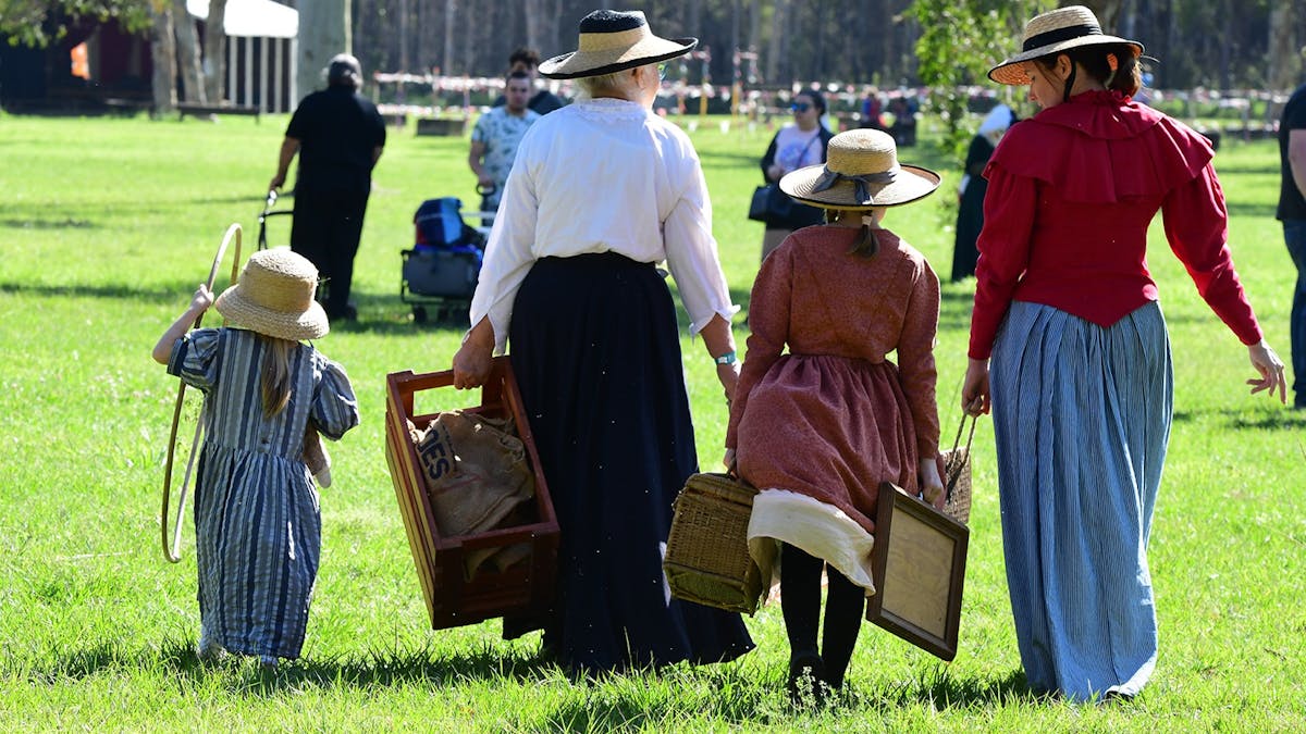 a group of ladies dressed in early 1900's costuming