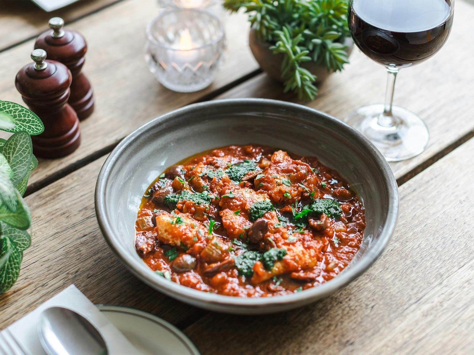 Sicilian Fish Stew with Barramundi, tomato, saffron, chilli, olives, potato, and salsa verde