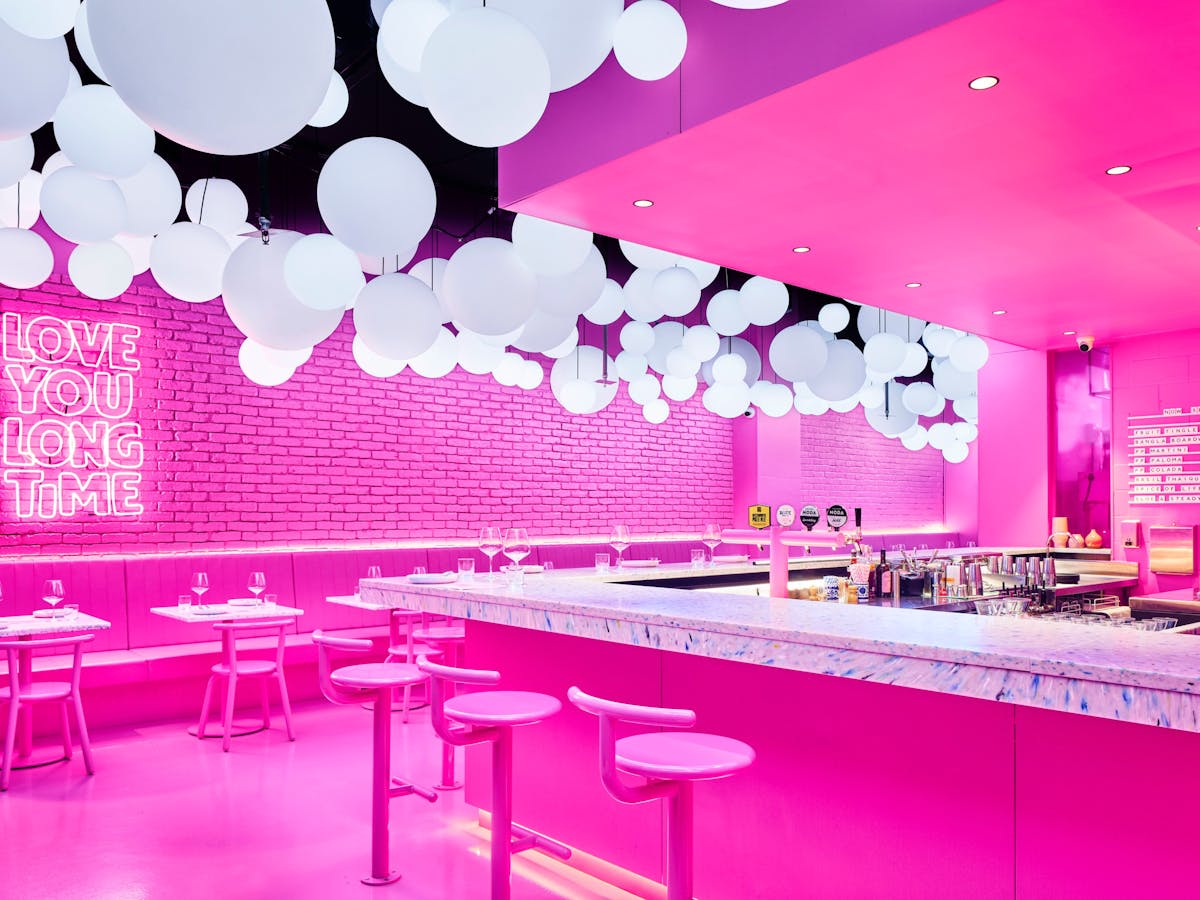 The bar and main dining area of PingPong's vibrant pink hued dining space