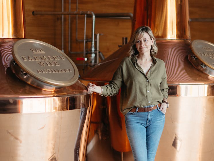 Owner & Distiller - Kylie Sepos Standing by two copper pot stills