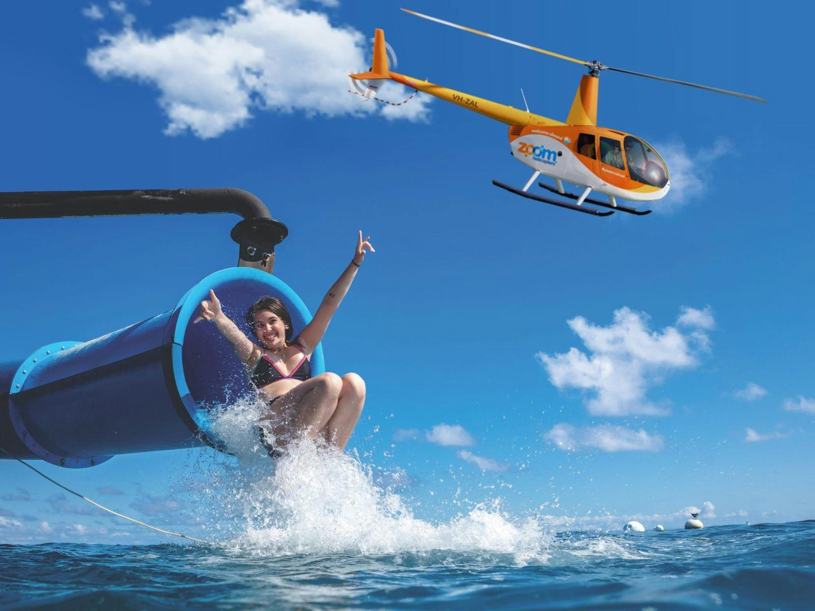 Girl sliding down the only waterslide on the Great Barrier Reef (Moore Reef), with a Zoom Helicopter
