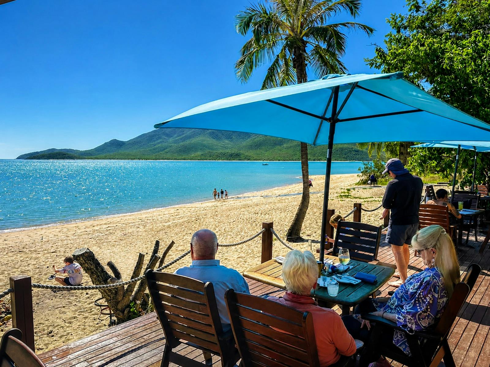 Golden beachfront dining deck at Montes Reef Resort overlooking the turquoise waters and tropical co Golden beachfront dining deck at Montes Reef Resort overlooking the turquoise waters and tropical co