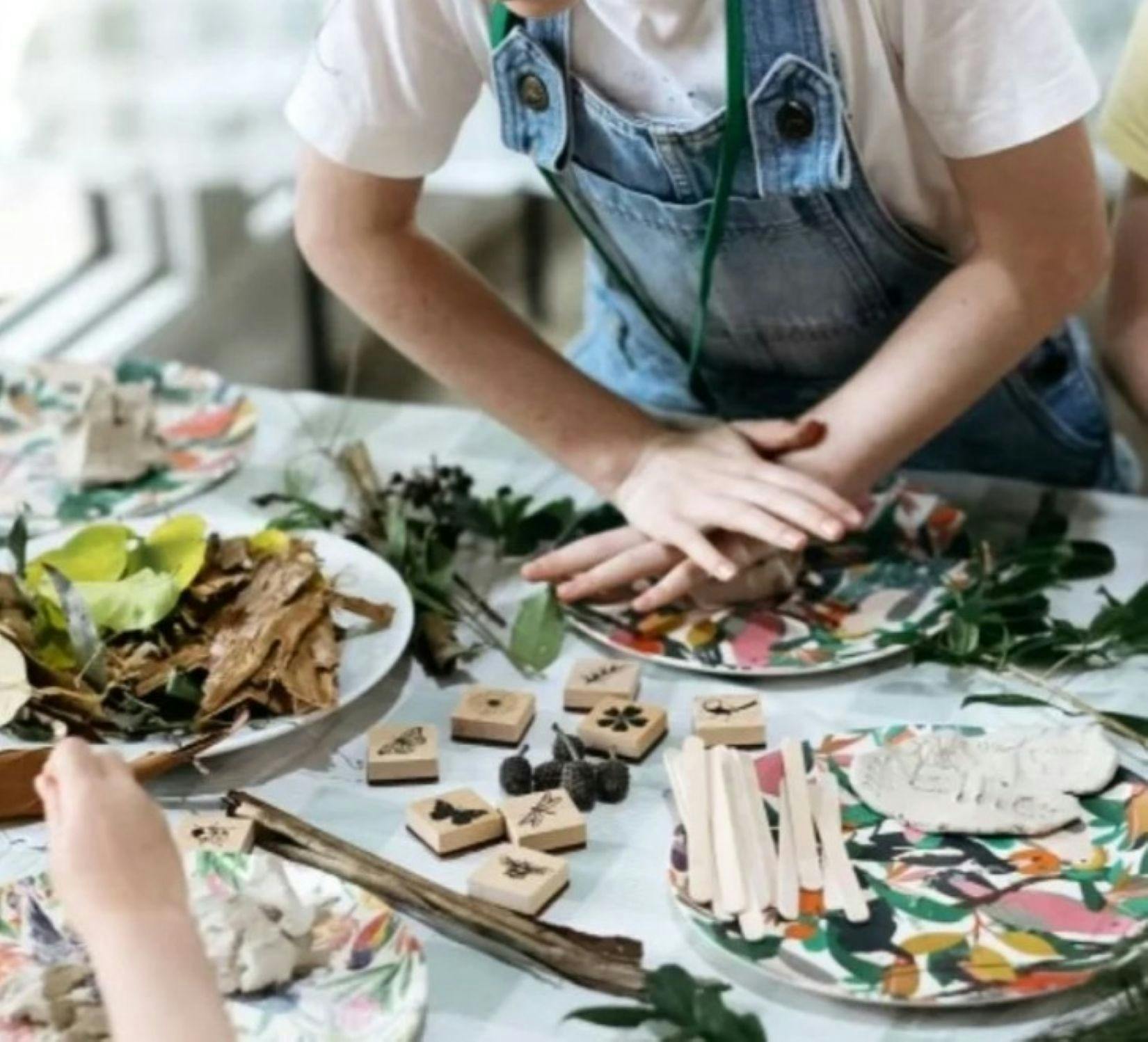 Two children playing with art and craft on a table