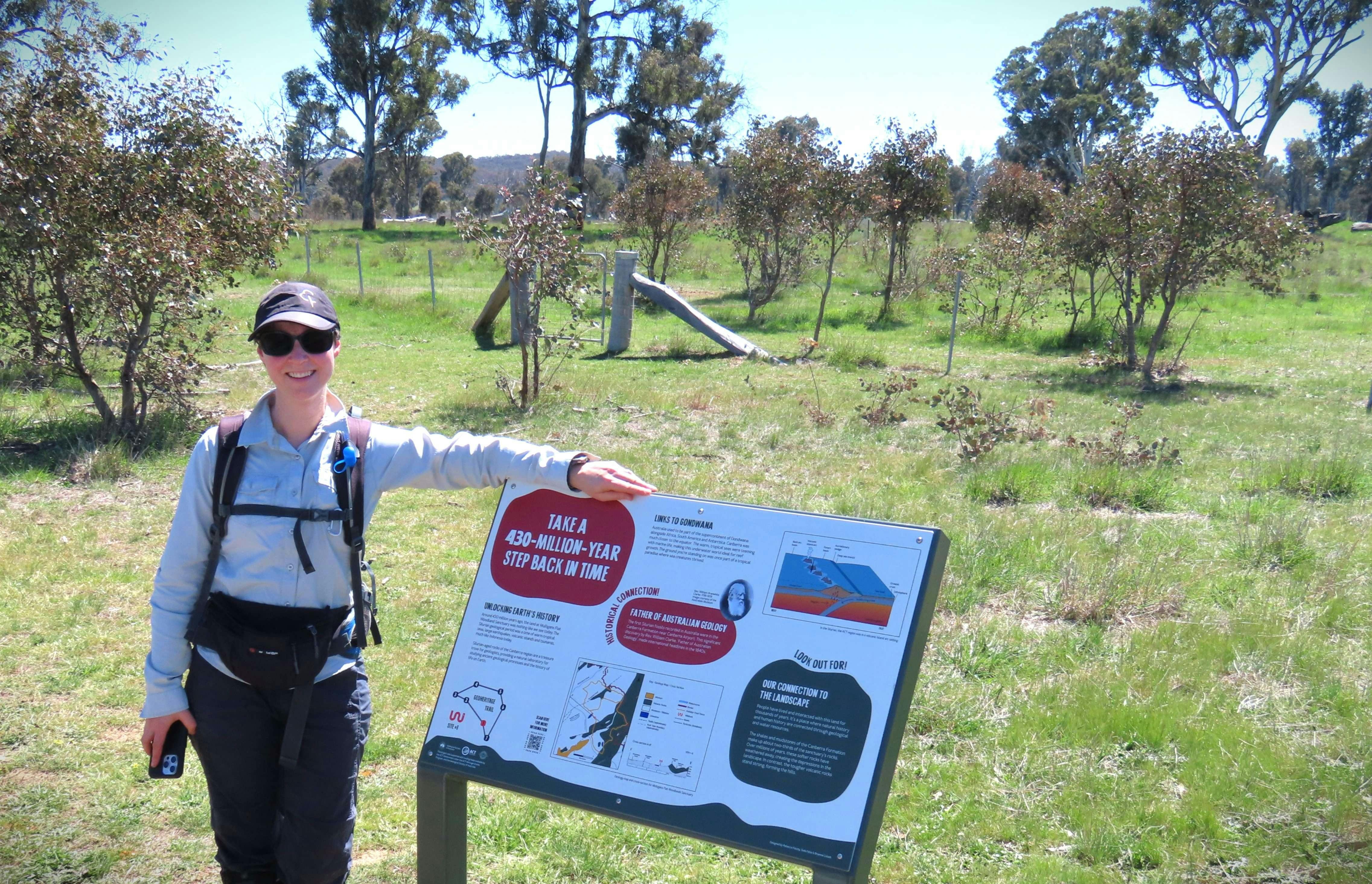 Woman standing beside informative sign