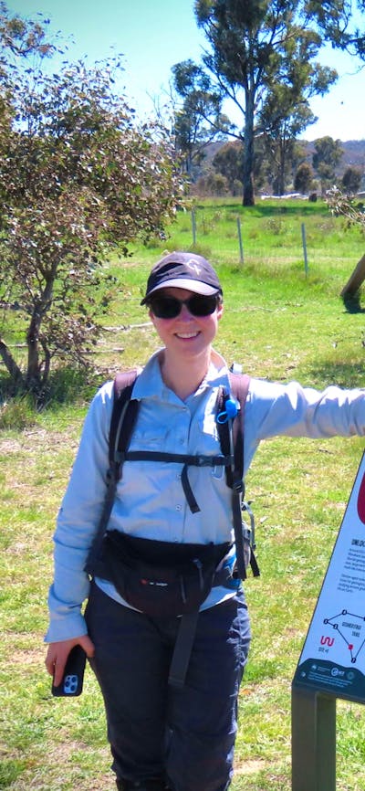 Woman standing beside informative sign