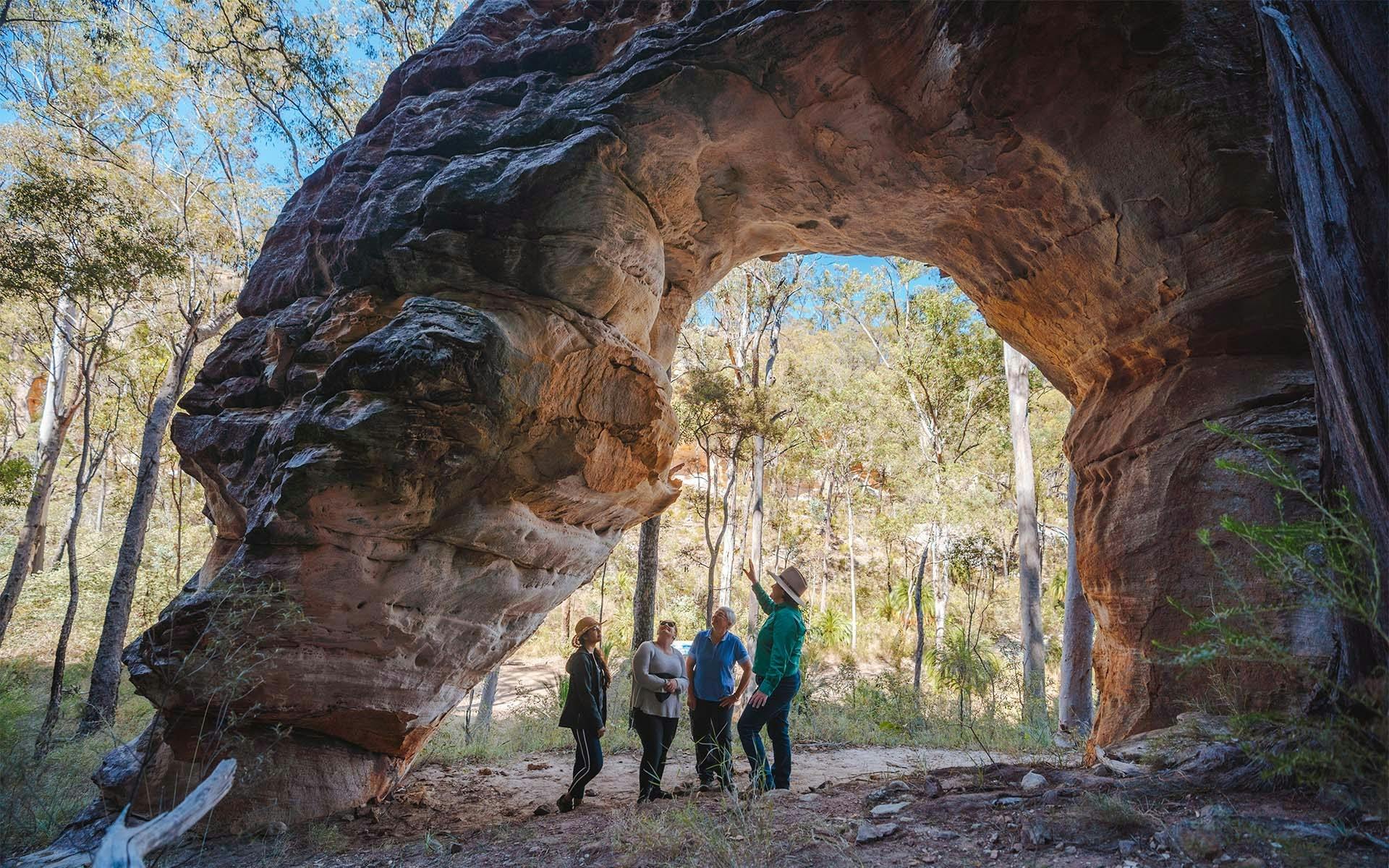 Boobook Explore guide showing visitors the natural rock arch in the Carnarvon Ranges