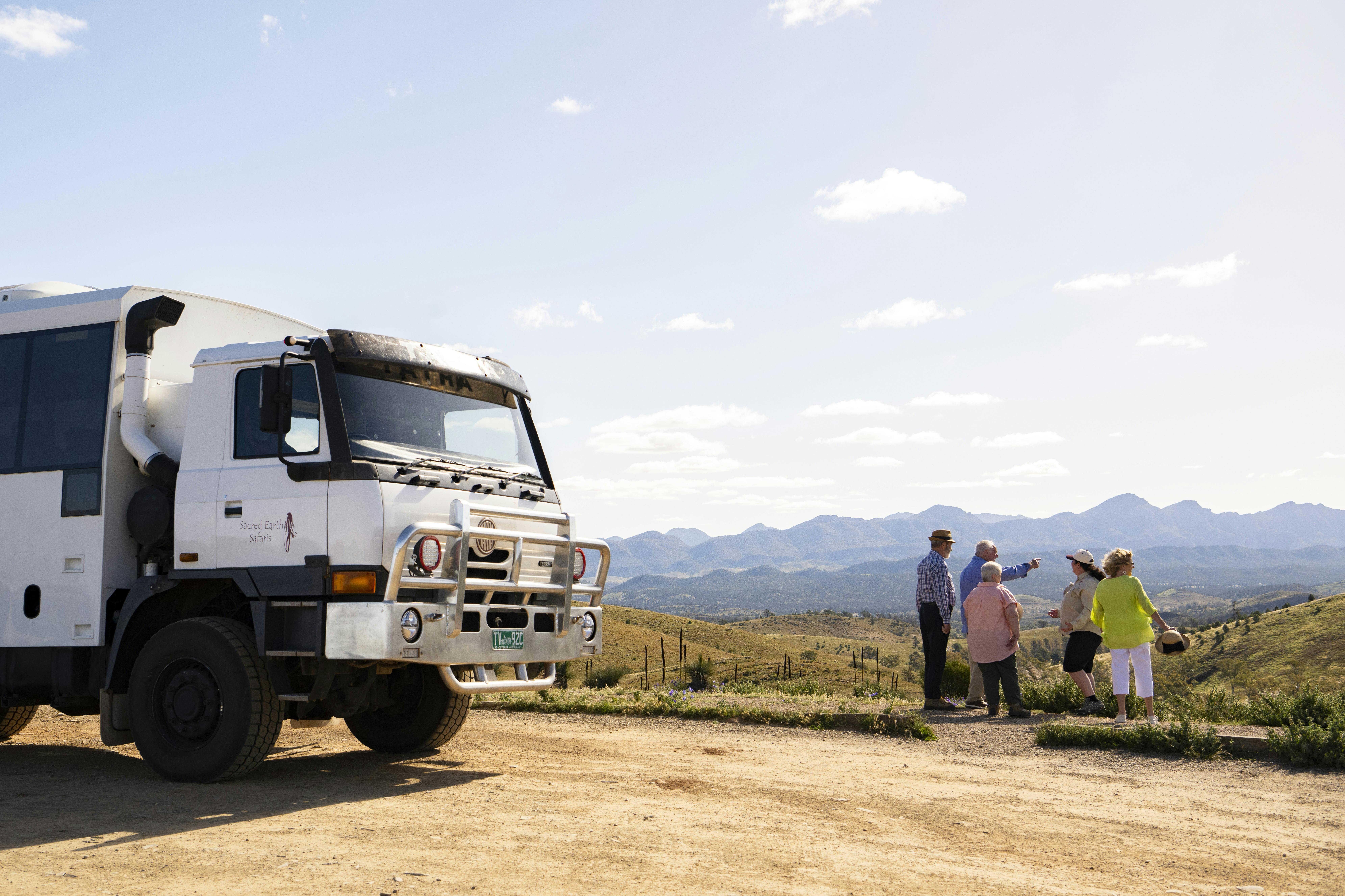 Small group of people looking out at  the Flinders Ranges with vehicle at the side