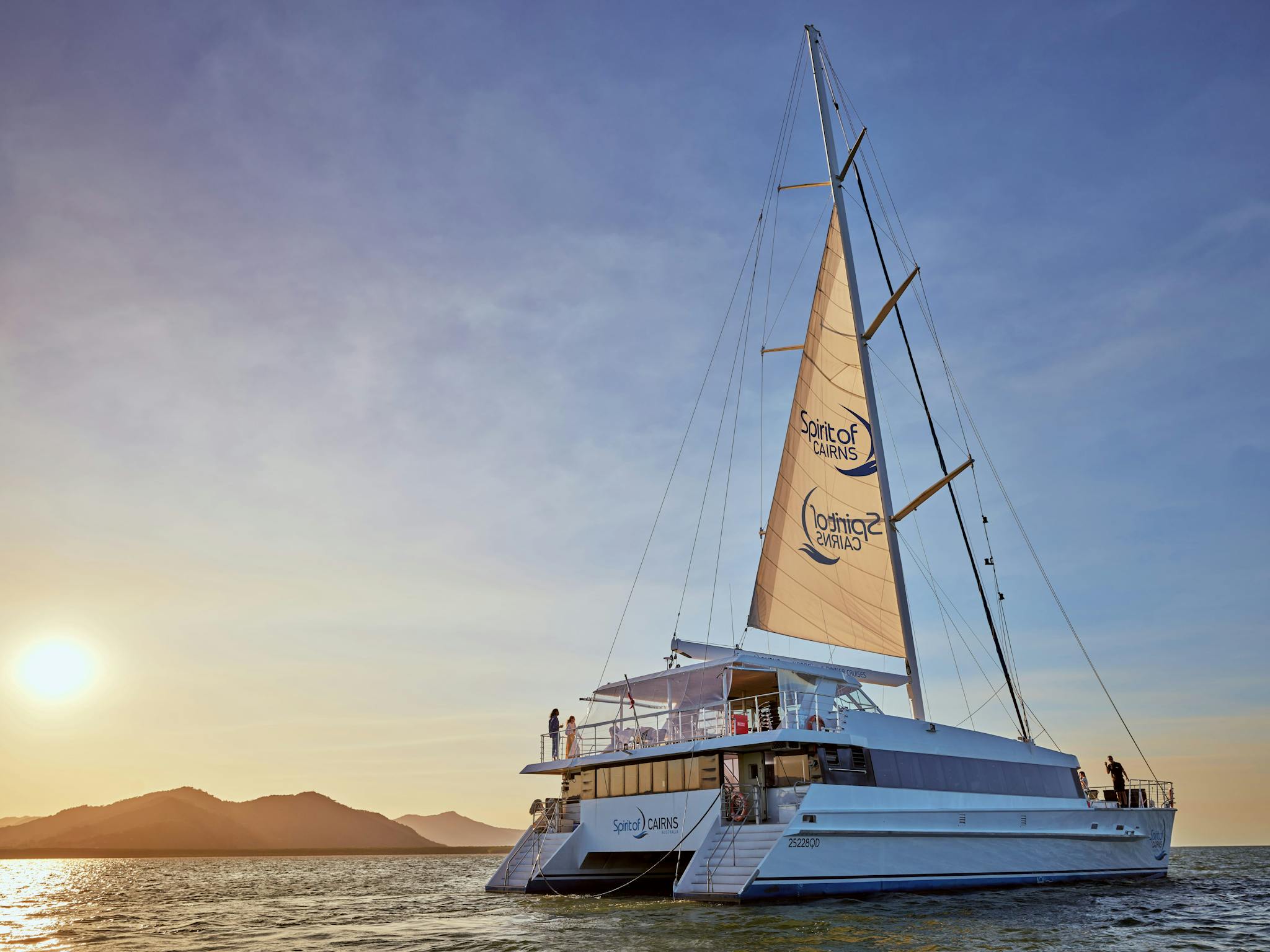 Spirit of Cairns dinner cruise sailing while the sun sets over the surrounding mountains. Spirit of Cairns dinner cruise sailing while the sun sets over the surrounding mountains.