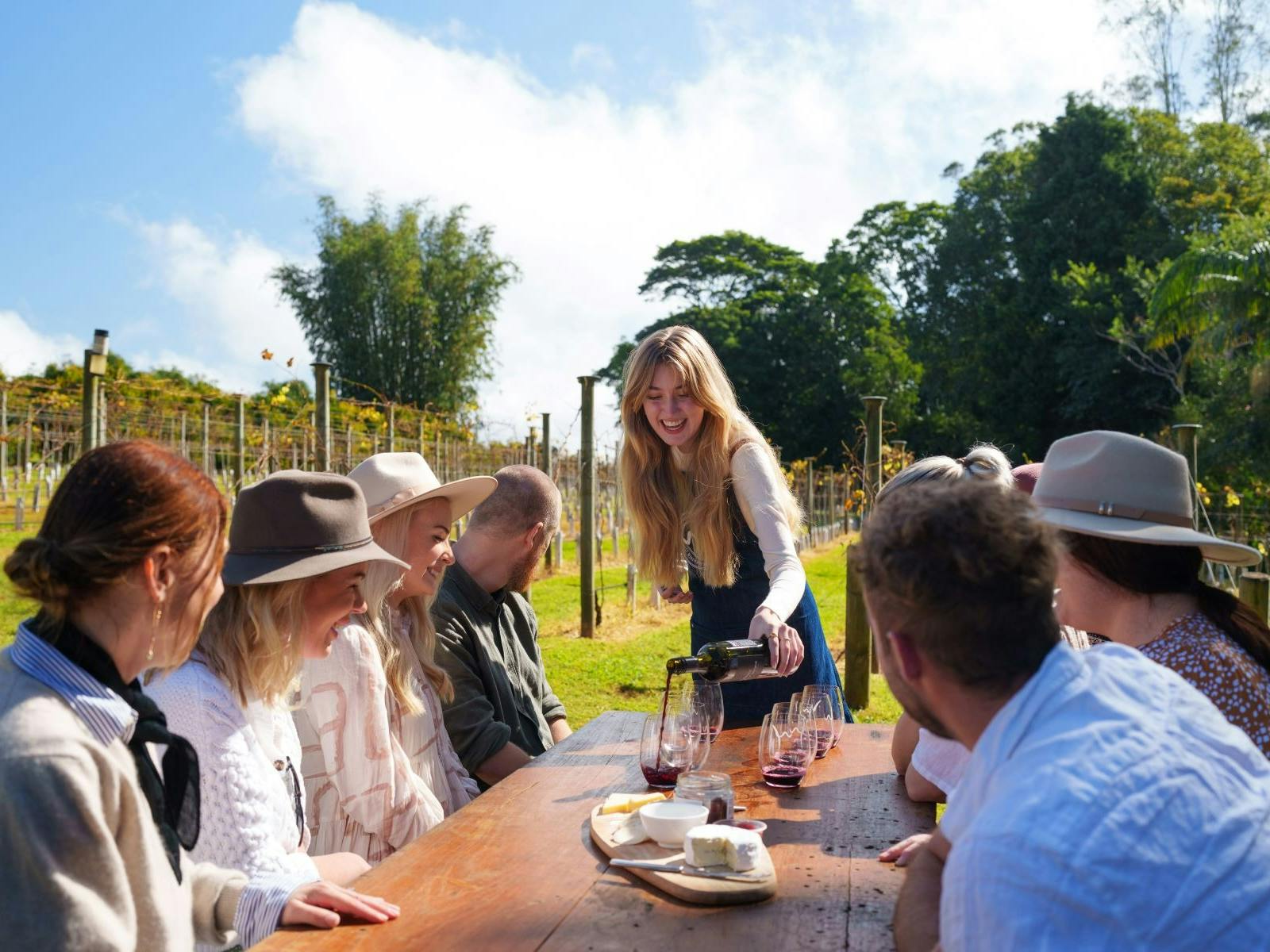guests outside at table being poured wine guests outside at table being poured wine