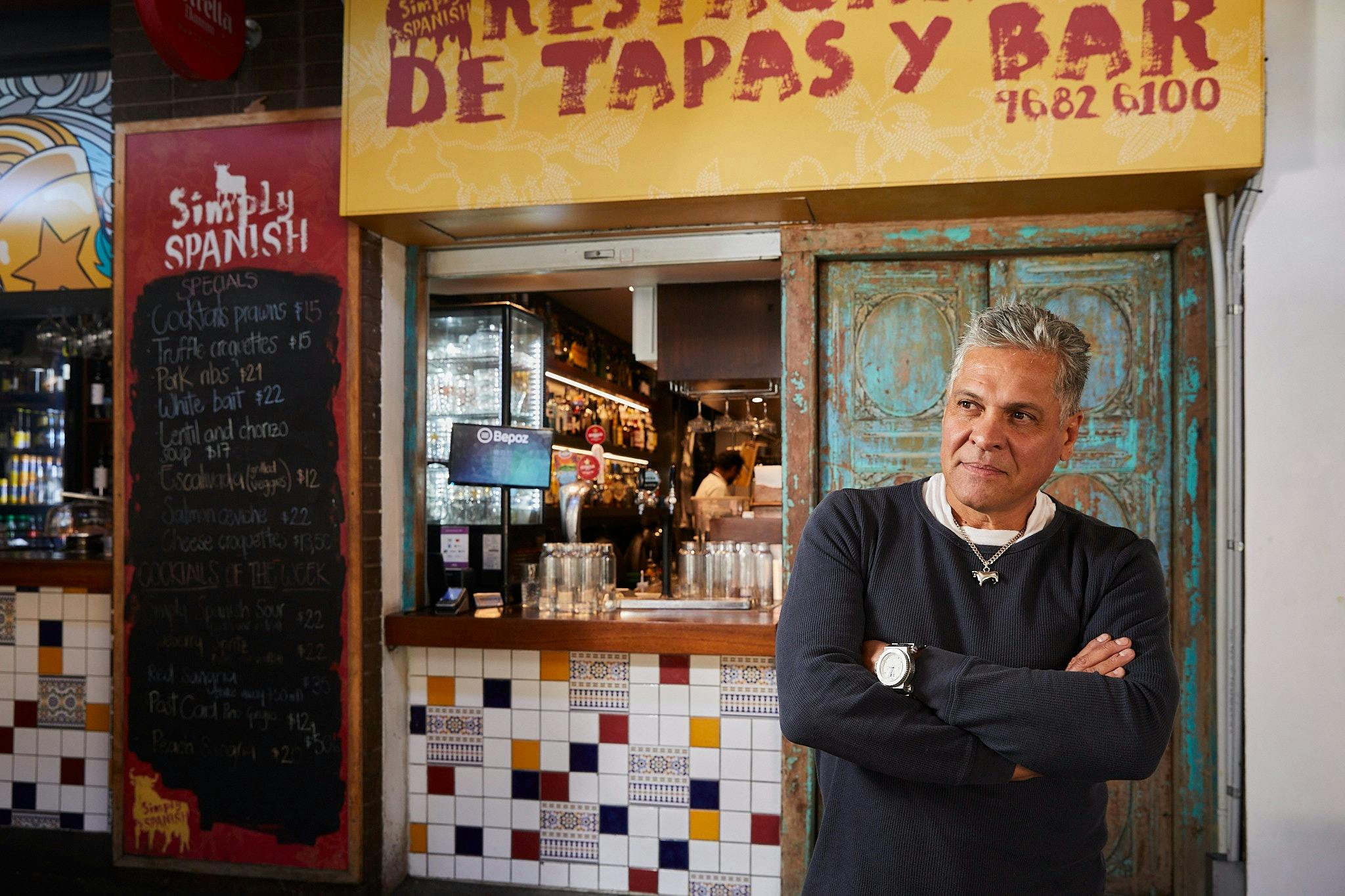 Trader outside Simply Spanish restaurant at South Melbourne Market.