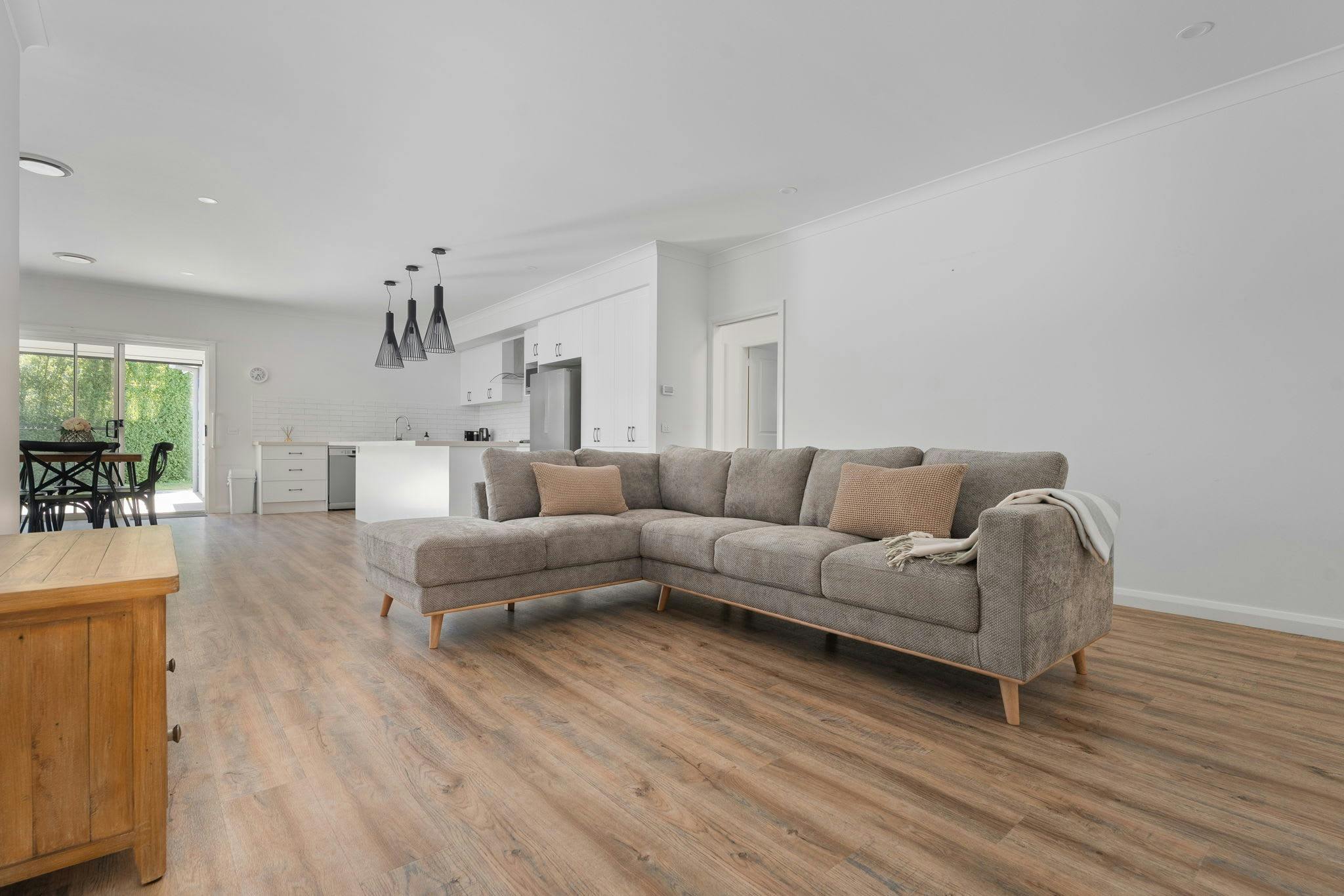 Living room with large L shaped couch, entertainment unit and tv