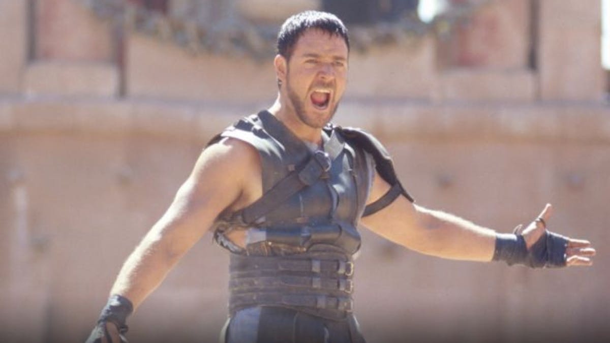 A still of Russell Crowe from the movie Gladiator shouting in the Colosseum, he looks fierce.
