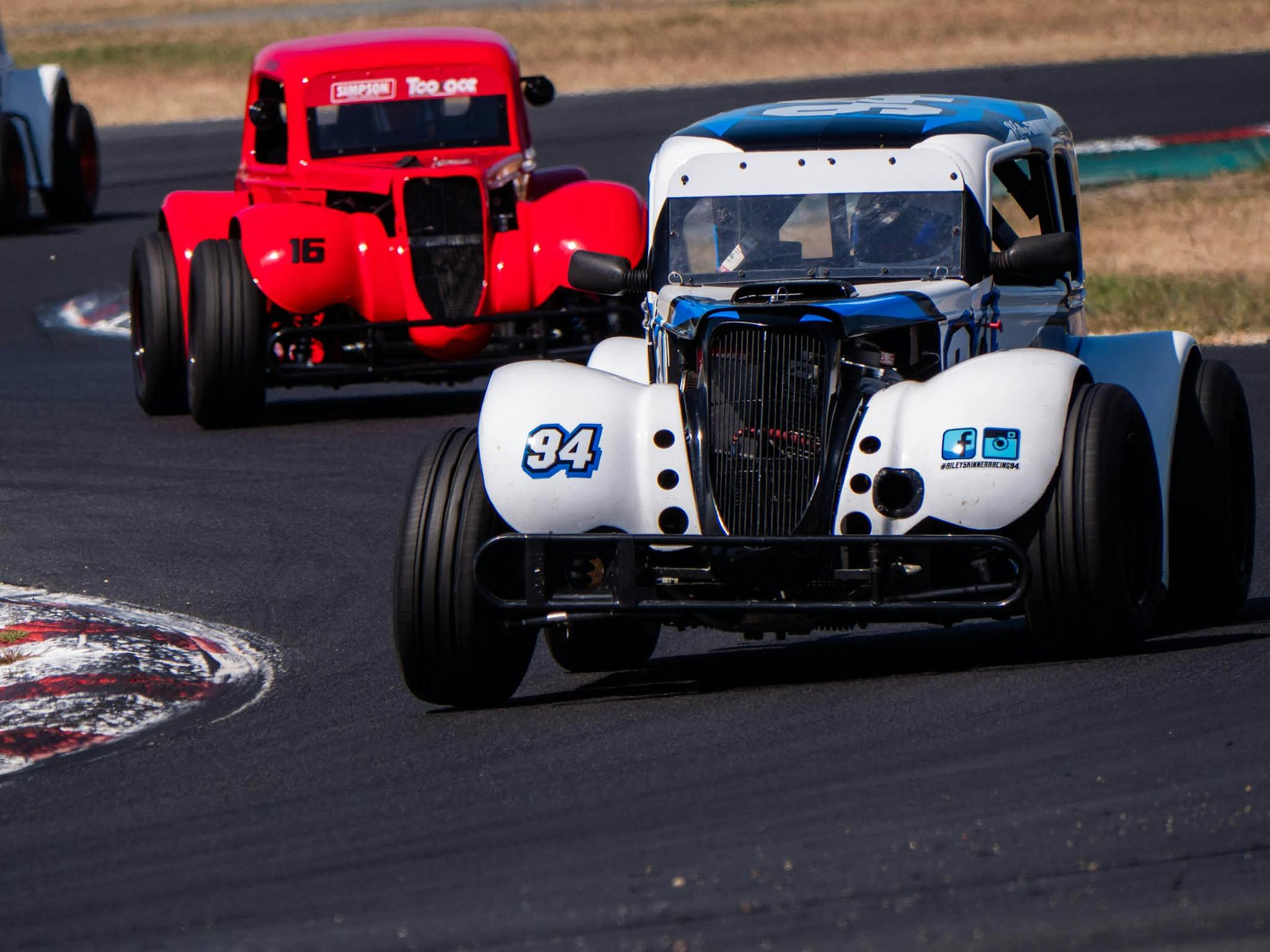 Two legend cars racing around Winton Motor Raceway
