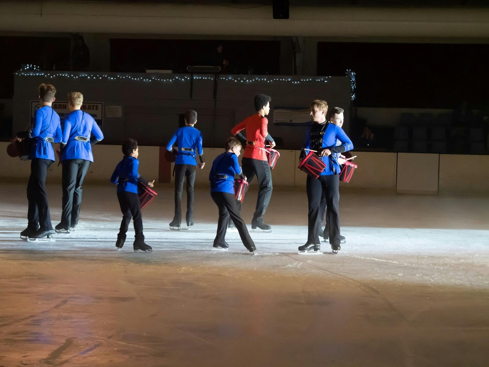 Figures skaters performing with drums.